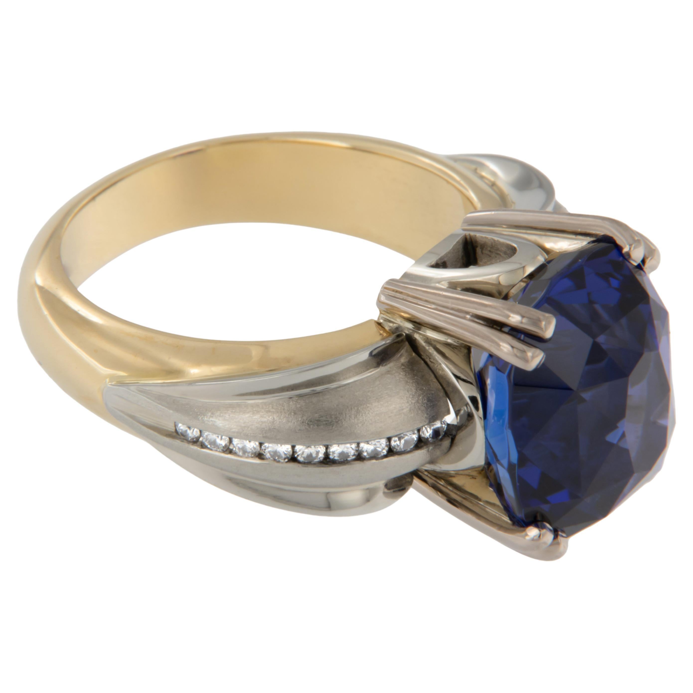 Phillip Youngman versteht es wie kein anderer, Edelsteine zum Leben zu erwecken, und dieser Tansanit ist ein leuchtendes Beispiel dafür! Dieser Ring von Yanke Designs aus 18 Karat Weiß- und Gelbgold setzt den 9,92 Karat schweren Edelstein perfekt in