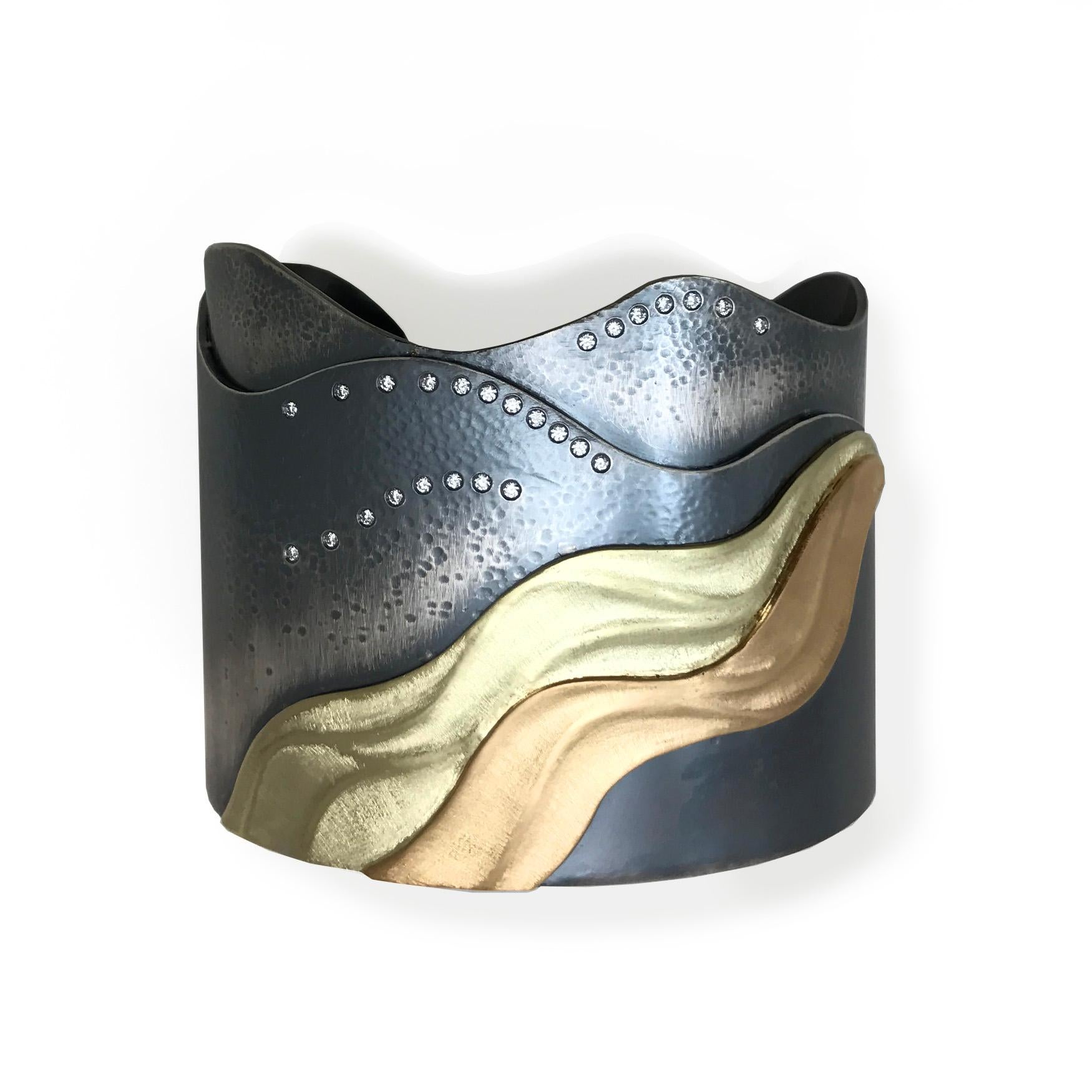 K.MITA's Shoreline Cuff instills a sense of peace and harmony. Waves of oxidized sterling silver gradually retreat from the sandy 18k yellow gold and 14k green gold shoreline. Diamonds 0.26ct sprinkled on the oxidized sterling silver sea reflect the