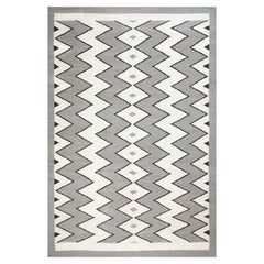 Tappeto in stile contemporaneo sud-occidentale con motivo Zig Zag, di colore bianco-grigio, di grande impatto.