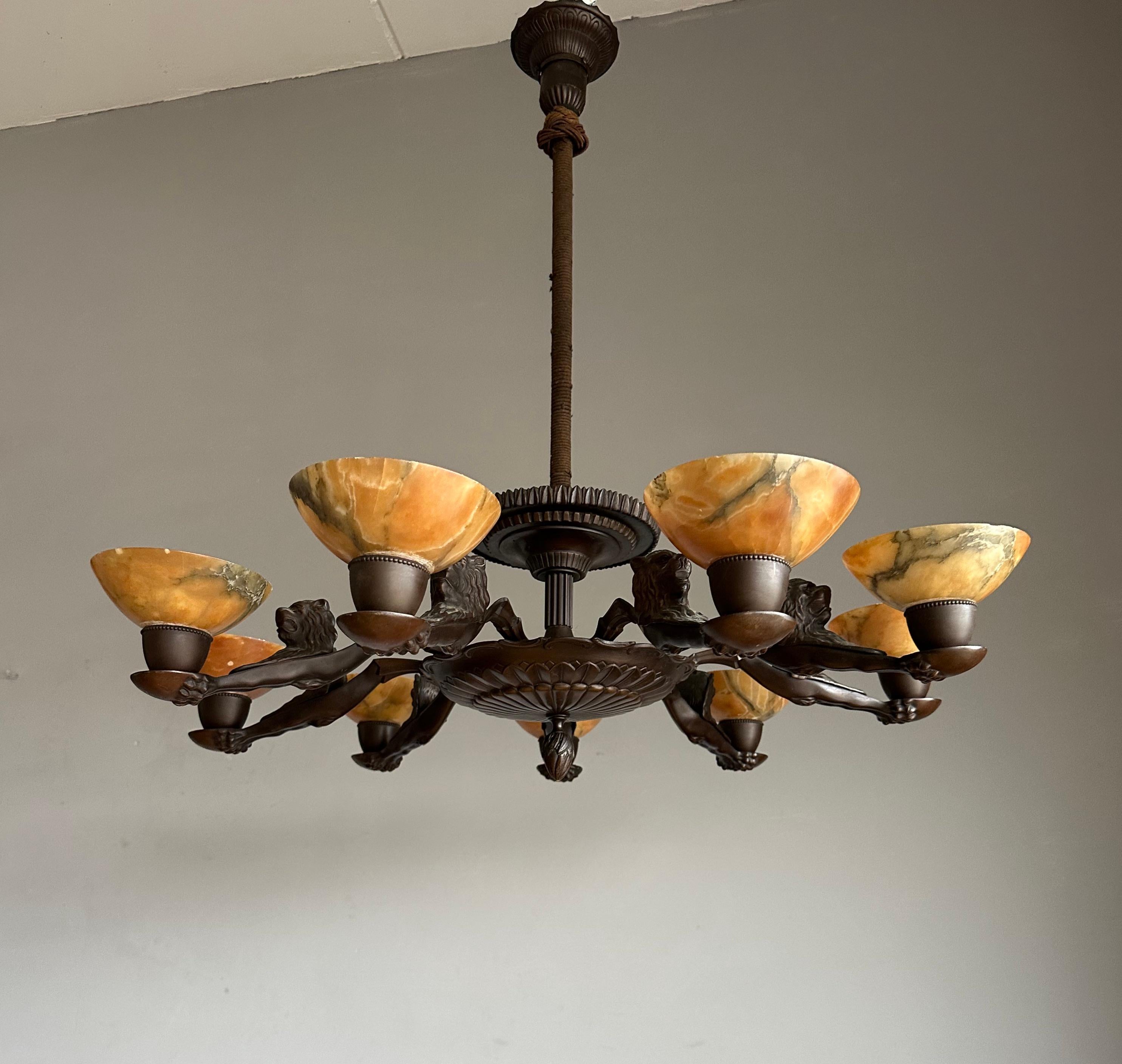 Highly stylish bronze pendant light with nine organic, amber color alabaster shades.

If you are looking for a truly stylish antique light fixture to grace your dining room or kitchen then this handcrafted work of art pendant from the 1920s could be
