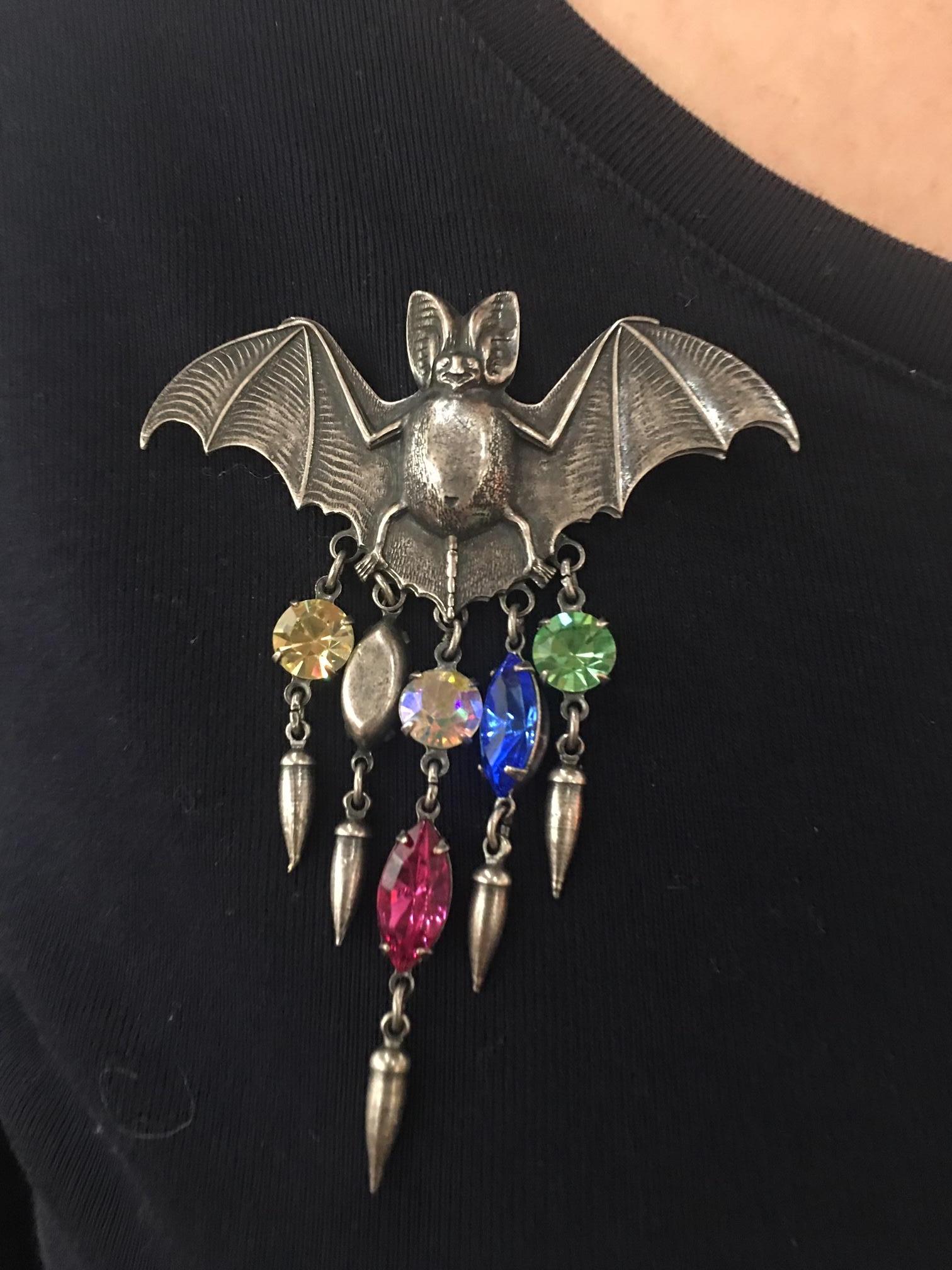 Whimsical and Fun Brooch featuring a Bat suspending Faux Gem enhancements; Signed Askew London; approx. 3.25 inches X 1.50 inches. Add your own Chic Style and Pizzazz to any outfit! To have, to hold, to keep Forever… An Heirloom to enjoy for