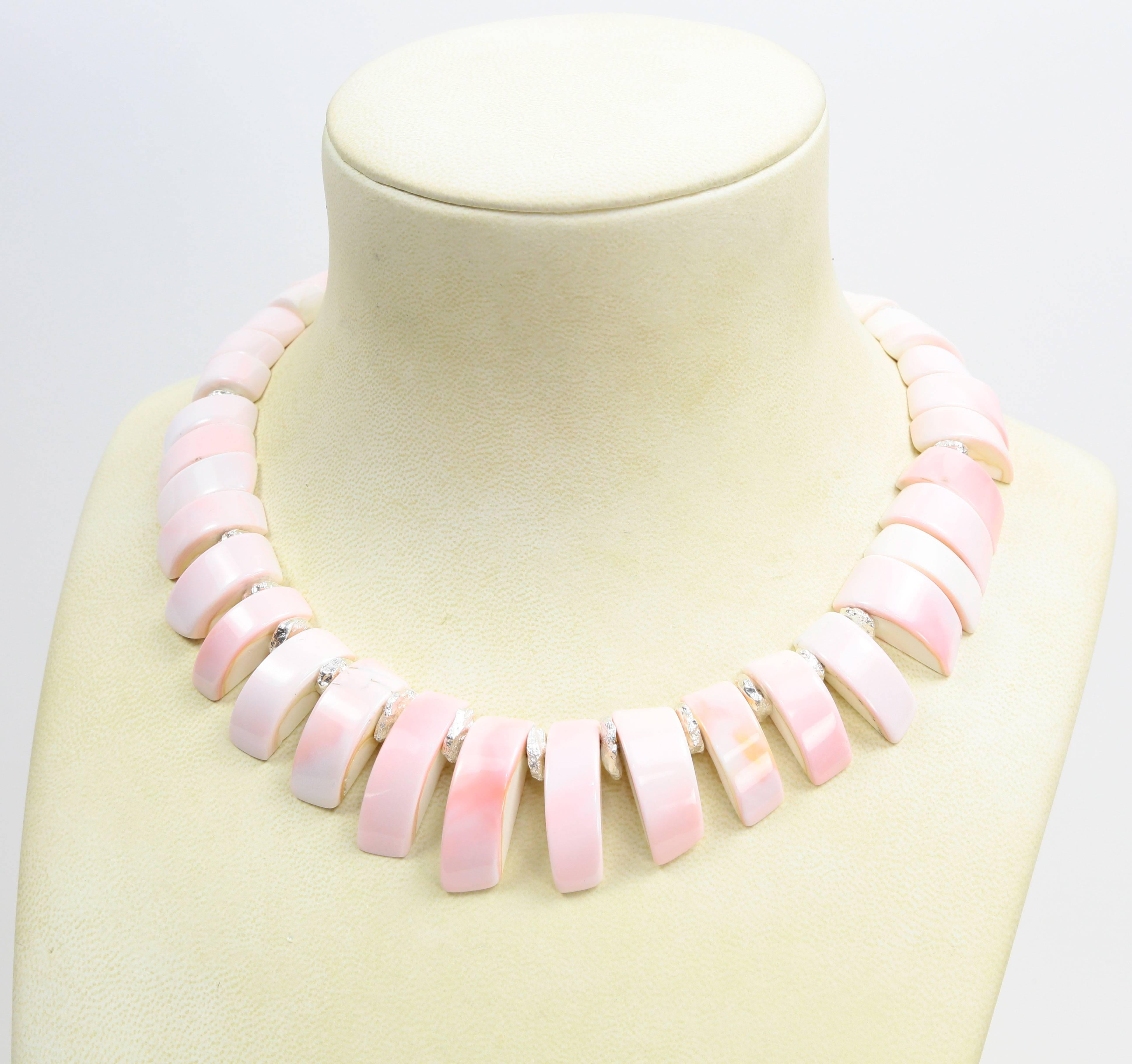 Stunning Necklace showcasing Luscious soft Pink Queen Conch Shell Beads accented by sterling silver spacers and complemented by a dynamic Sterling Silver circular closure; Hand knotted on matching pink thread. Spectacular in its simplicity! A