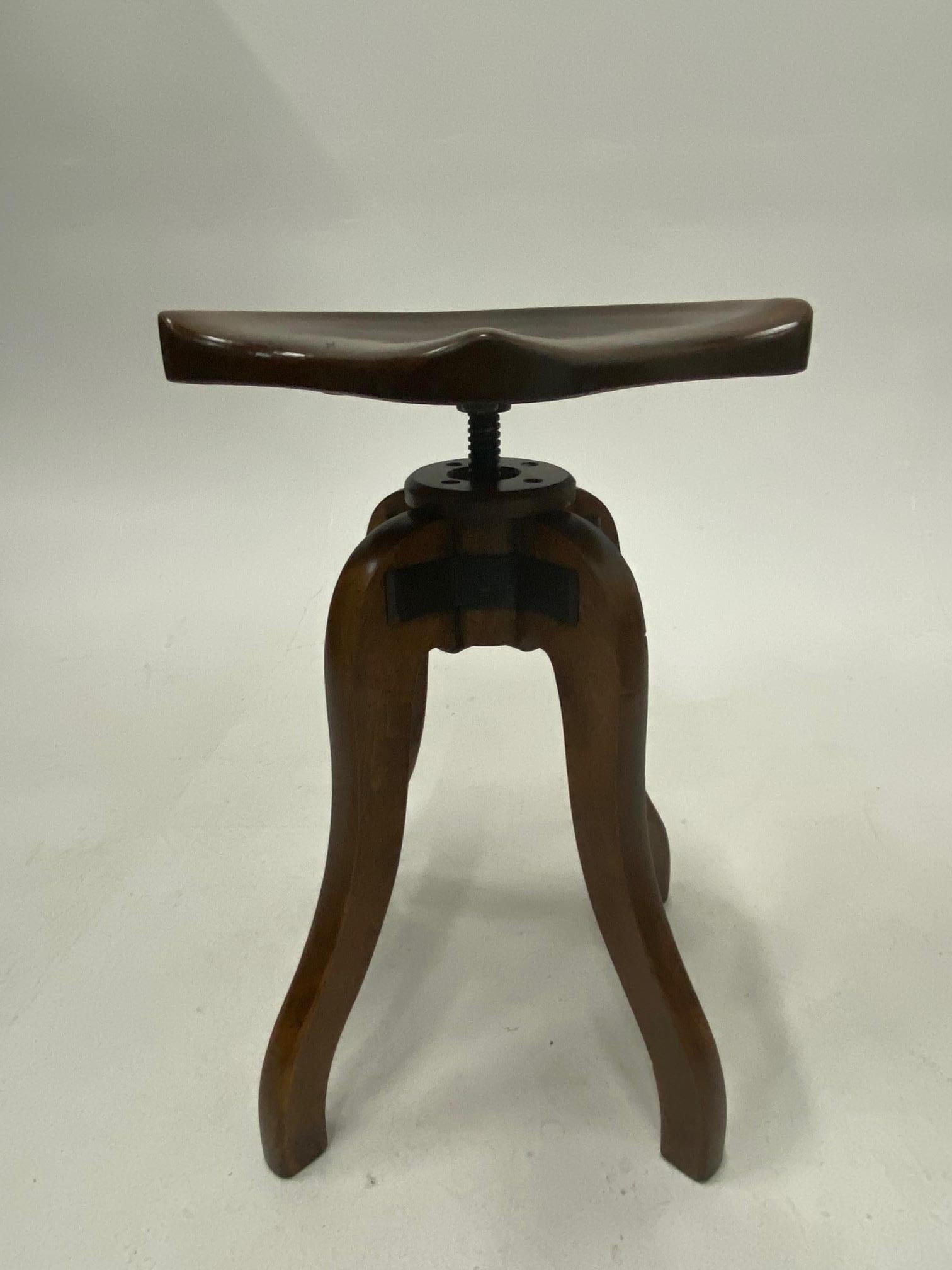 Handsome beautifully crafted adjustable carved wood industrial stool having saddle shaped seat and curvy legs.
Measures: Lowest 23
Highest 26.