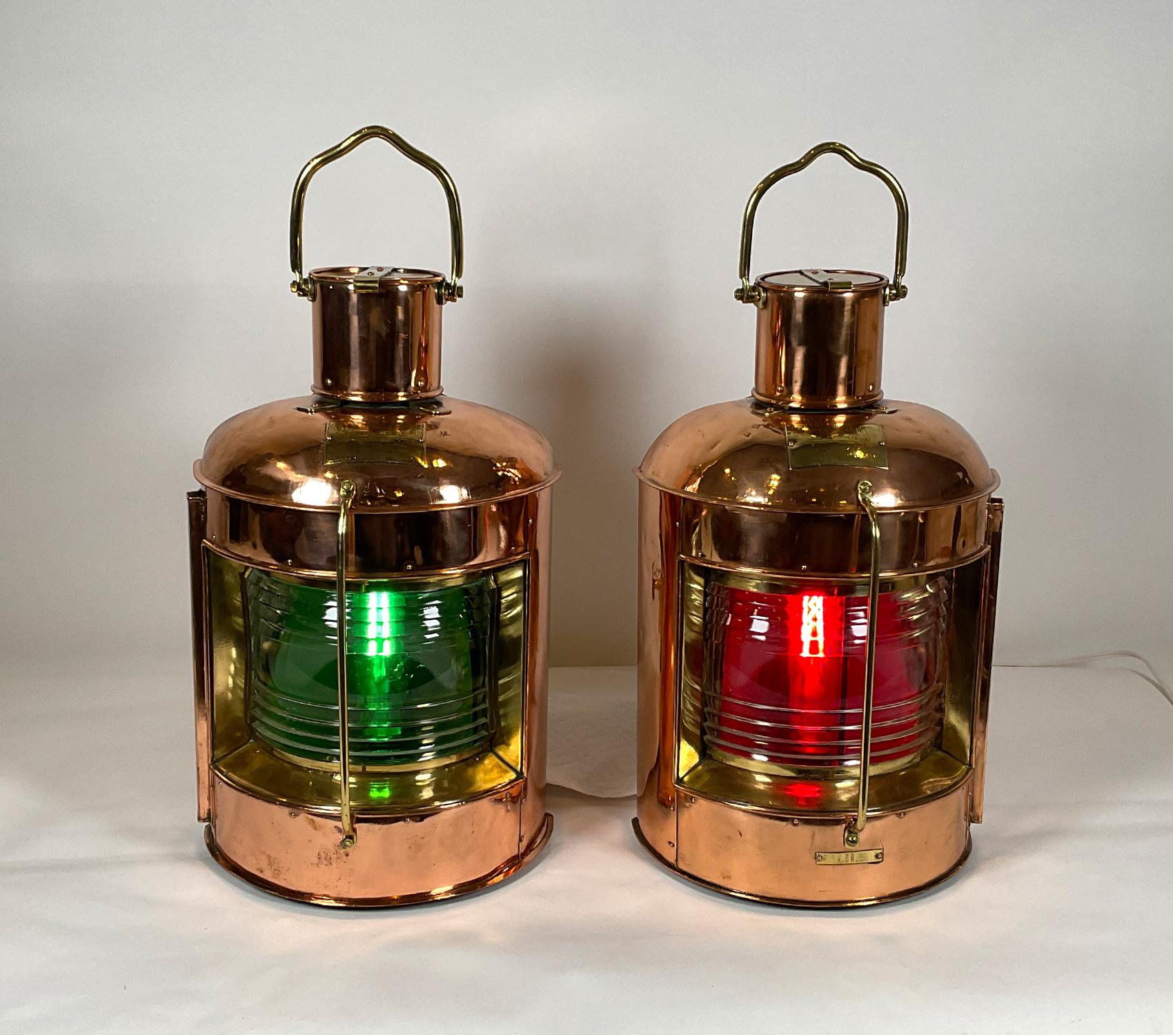 Pair of highly polished copper and brass ship’s lanterns. The polished and lacquered copper cases have brass bezels around the lenses, protective brass bars, handles, badges, etc. Fresnel glass lenses, red and green filters. Good strong pair of