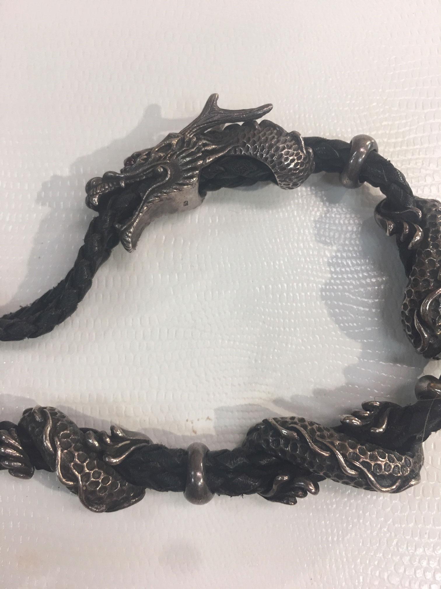 Undeniable unique, a blend of a Sterling Silver Dragon intertwined on a hand knotted black leather bracelet. It takes its inspiration from mythical beasts as majestic dragons encircle your wrist - from head down to coiled tail. For added detail, the