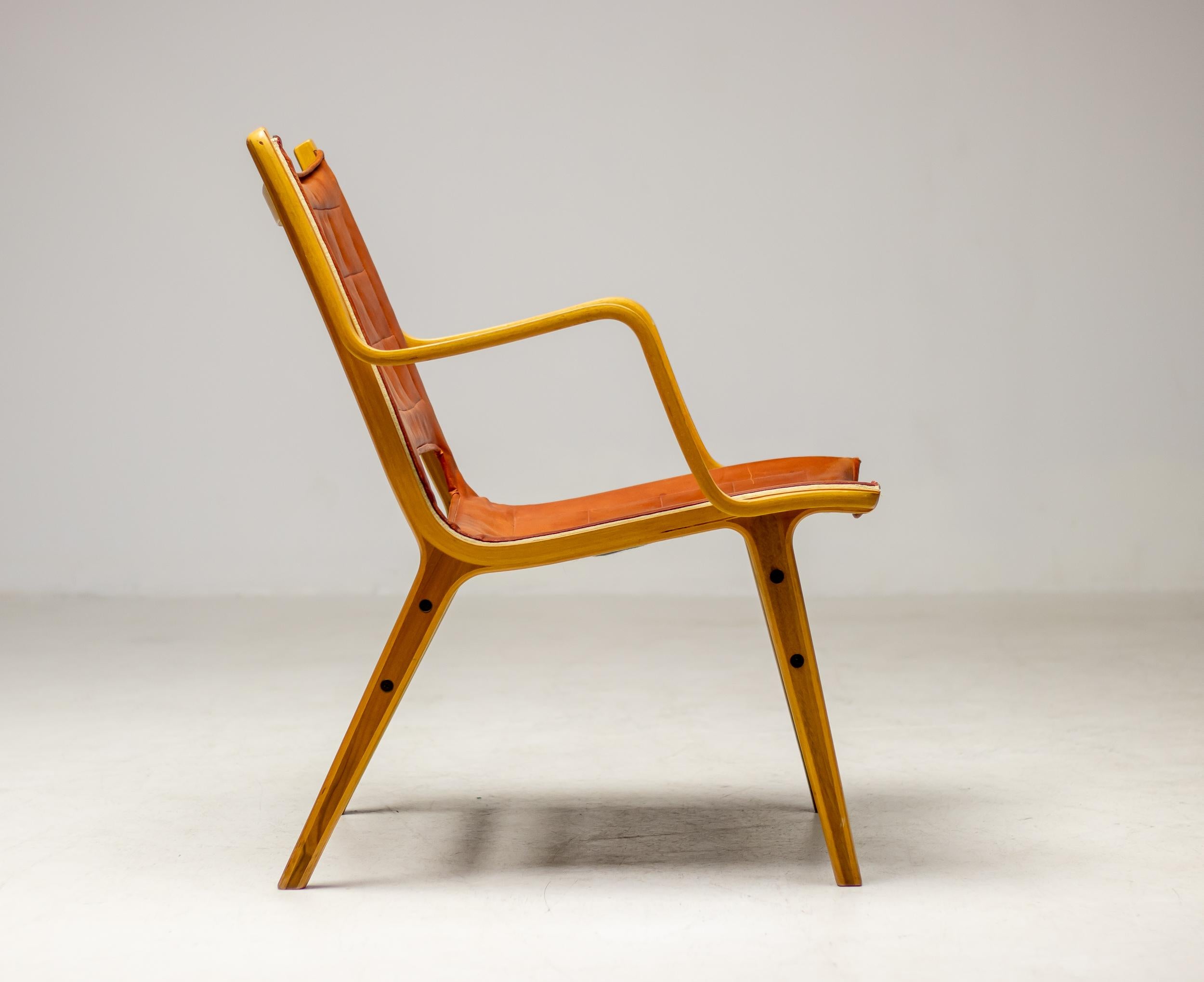 Armchair designed by Peter Hvidt and Orla Mølgaard–Nielsen and produced in 1963 by Fritz Hansen, Denmark.  The chair is press shaped in laminated beechwood, the seat is upholstered with all original cognac leather. The legs feature a teak core.
