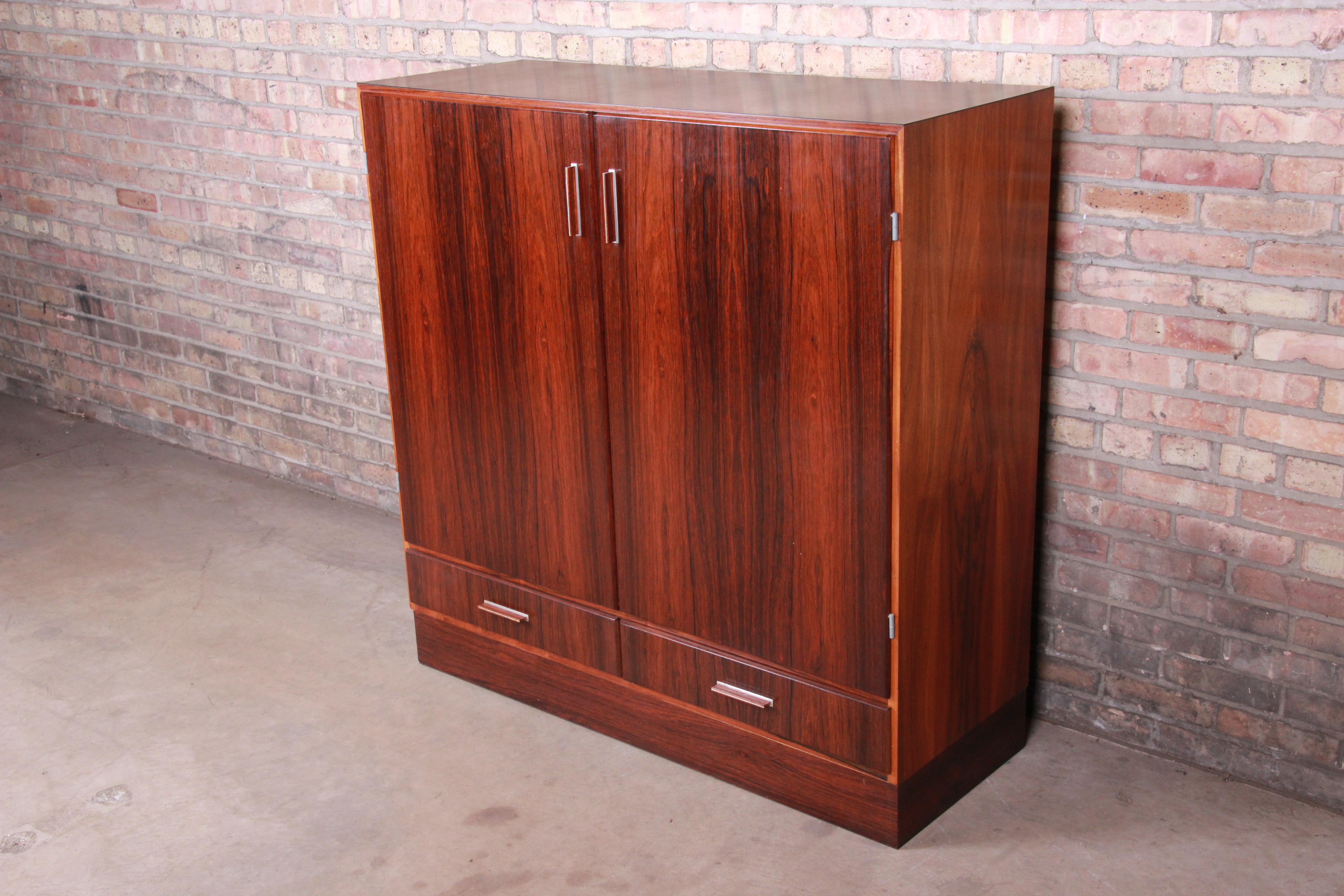 A rare and exceptional Danish modern bar cabinet

By Axel Christiansen Odder for ACO Møbler

Denmark, circa 1960s

Bookmatched Brazilian rosewood, interior mirror, laminate top and pull-out serving tray.

Measures: 47.25