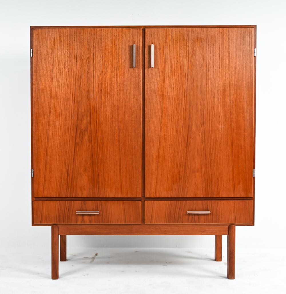 Endlessly stylish and functional, this rare highboy cabinet by Axel Christiansen Odder for ACO Møbler features a large shelved compartment over two small drawers, accented by aluminum-trimmed sculptural wood handles. It is signed inside the upper