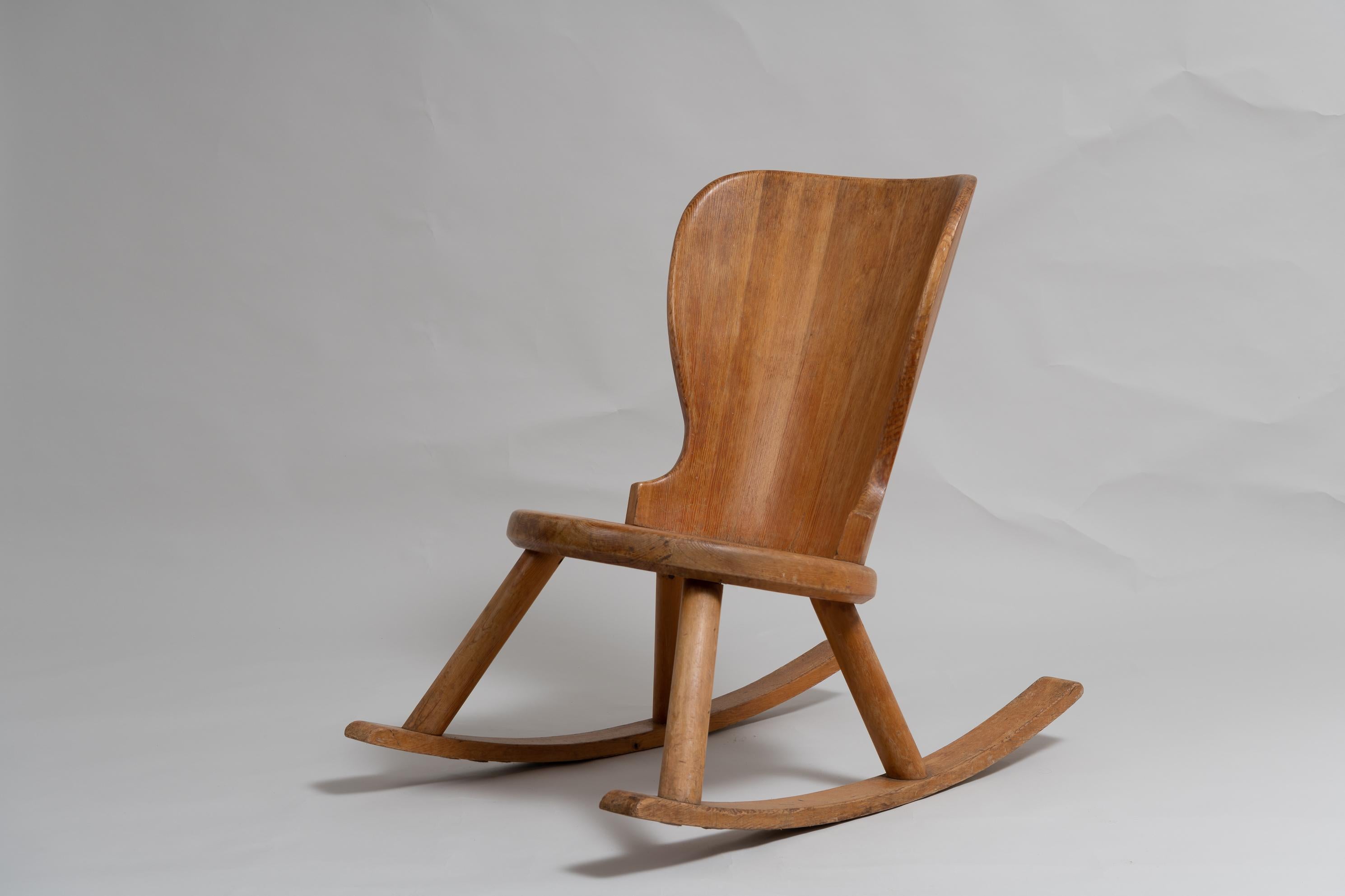 Swedish hand-made pine rocking chair in the style of Axel Einar Hjorts furniture. The rocking chair is in good vintage condition consistent with the age and has minor traces of use. Typical example of the Scandinavian Modern style with elegant lines