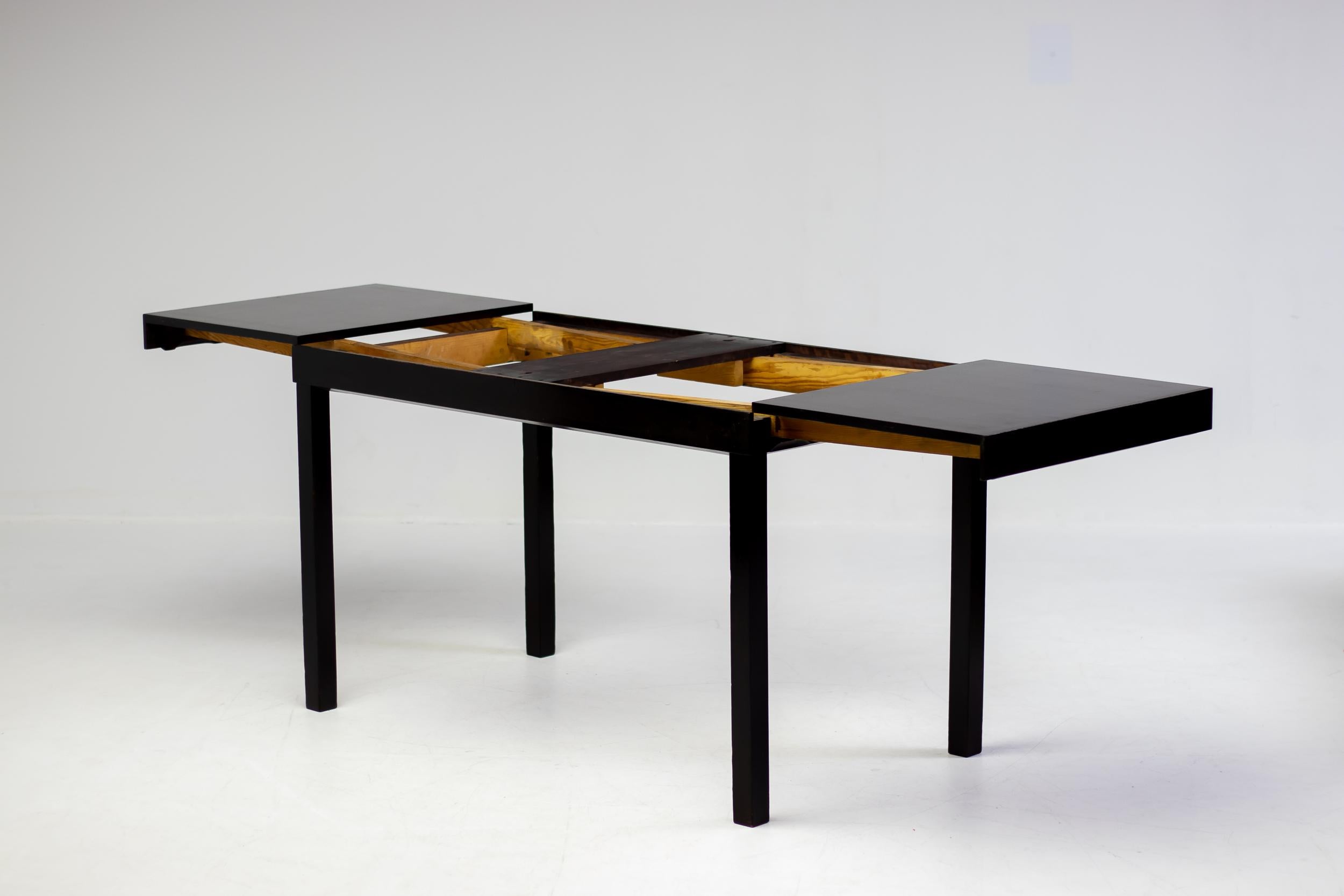 This beautiful Scandinavian Modern extendable dining table or writing desk is designed by Axel Einar Hjorth for NK in the 1930s.  The base and extension leaves are lacquered in a wonderful very dark brown chocolate color, the top is veneered in book