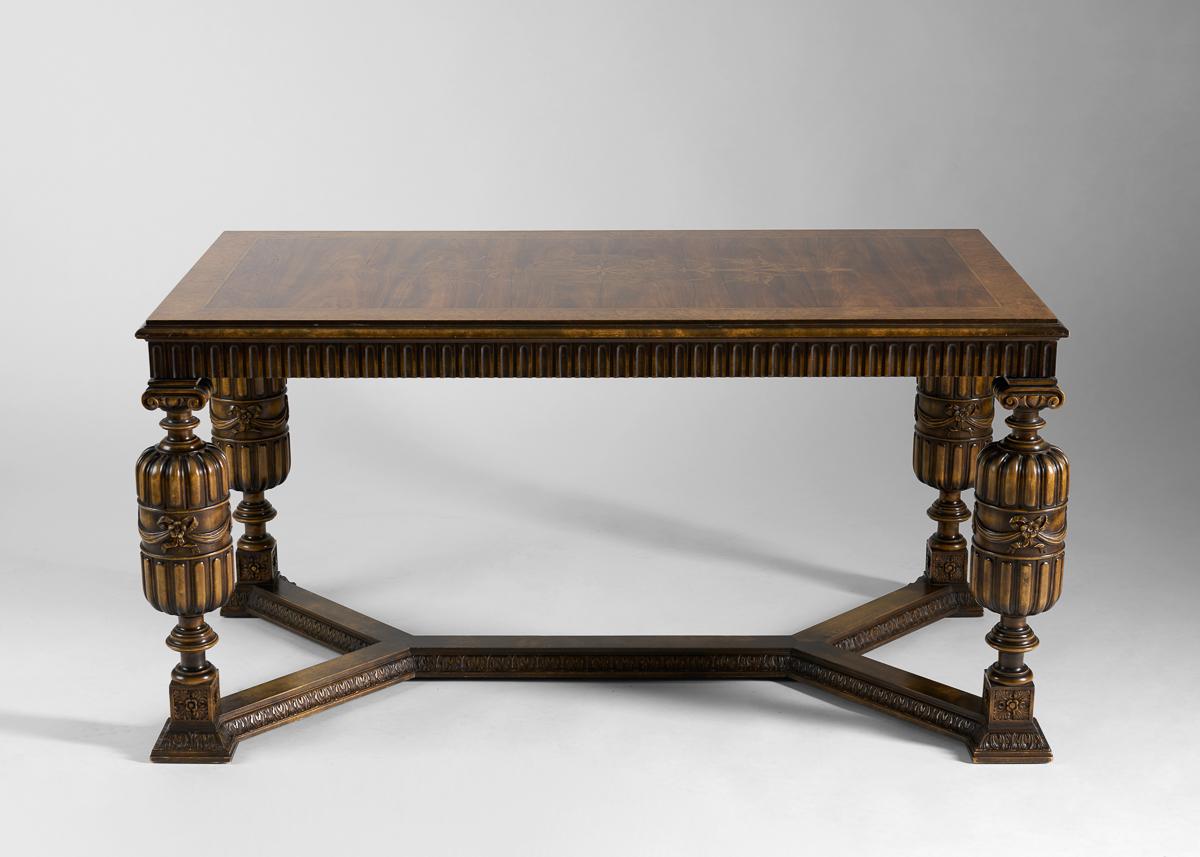Each element of this extraordinary table invites closer inspection. And yet, despite its lush veneers, unusual geometric base, and legs which taper and bulge in an elaborately carved sequence, it’s more than its constituent merits—it is, rather, a