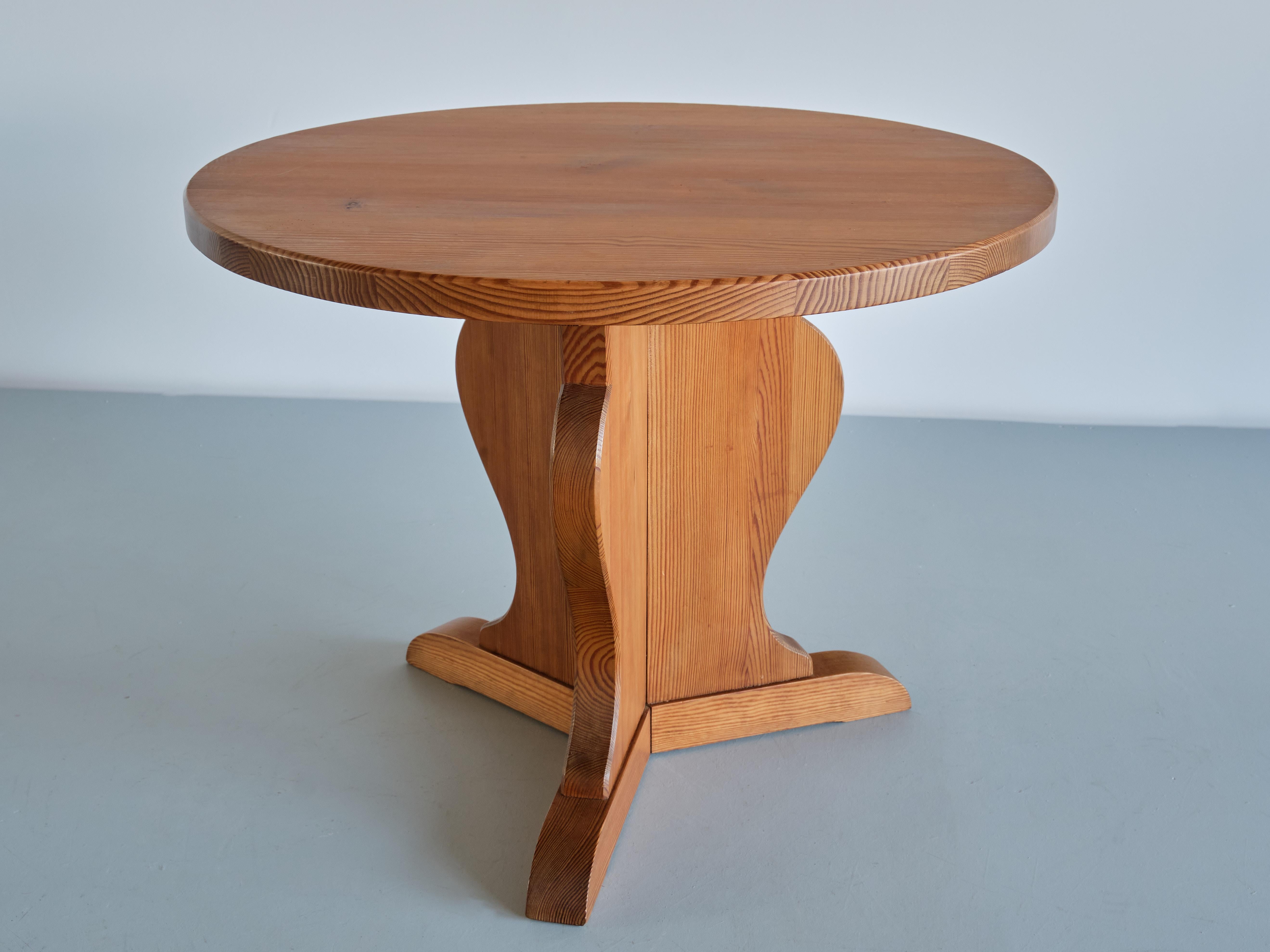 This occasional or side table was produced by Nordiska Kompaniet in the late 1930s. Made of solid pine, the round top is resting on three cleverly constructed legs that meet up in the center. The amphora-shaped base is a reference to the