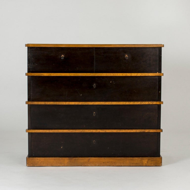Produced by AB Nordiska Kompaniet, Stockholm. Reverse with manufacturer’s metal label impressed with register number and date NK R33930 - C16 6 31. Designed in 1929, executed in 1931. Material: Birch and ebonized birch.

This rare chest of drawers