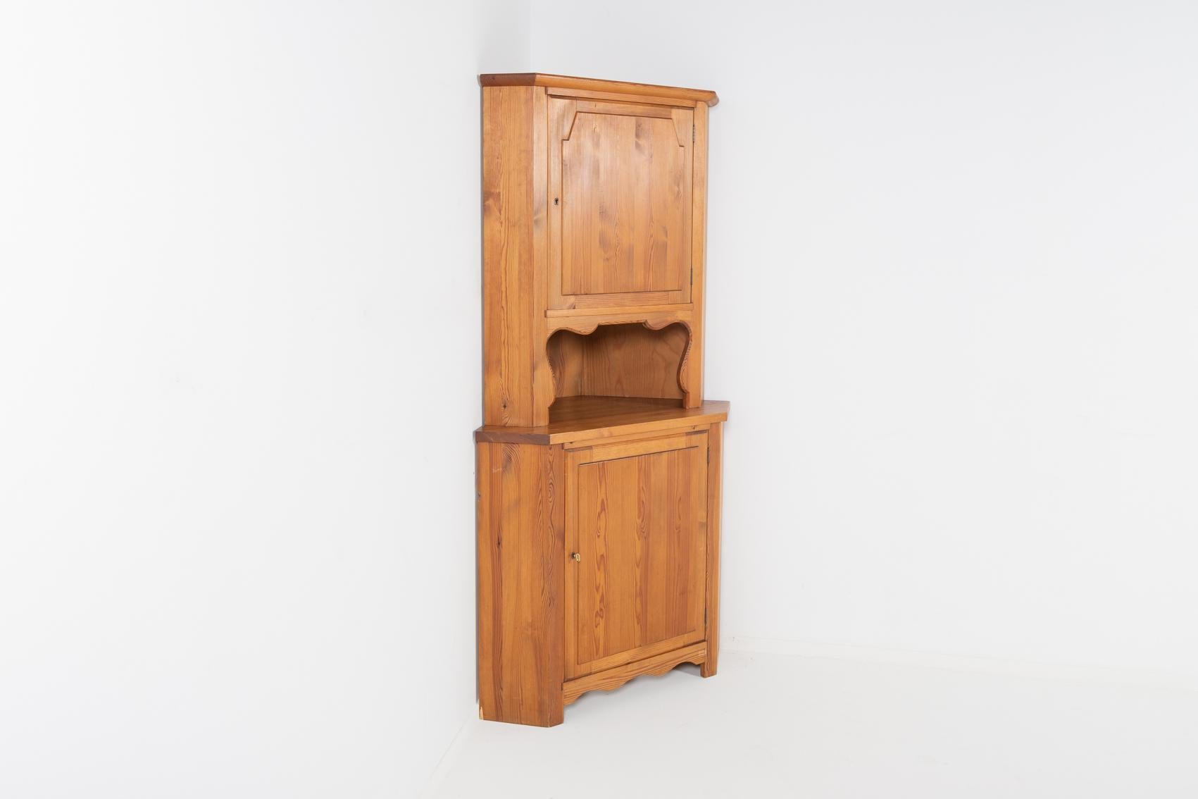 Scandinavian Modern solid pine corner cabinet by Swedish icon Axel Einar Hjorth for Nordiska Kompaniet from the acclaimed so called “Sportstugemöbel” series, produced in 1940s. Made from solid acid treated pine wood. Two cabinets with individual