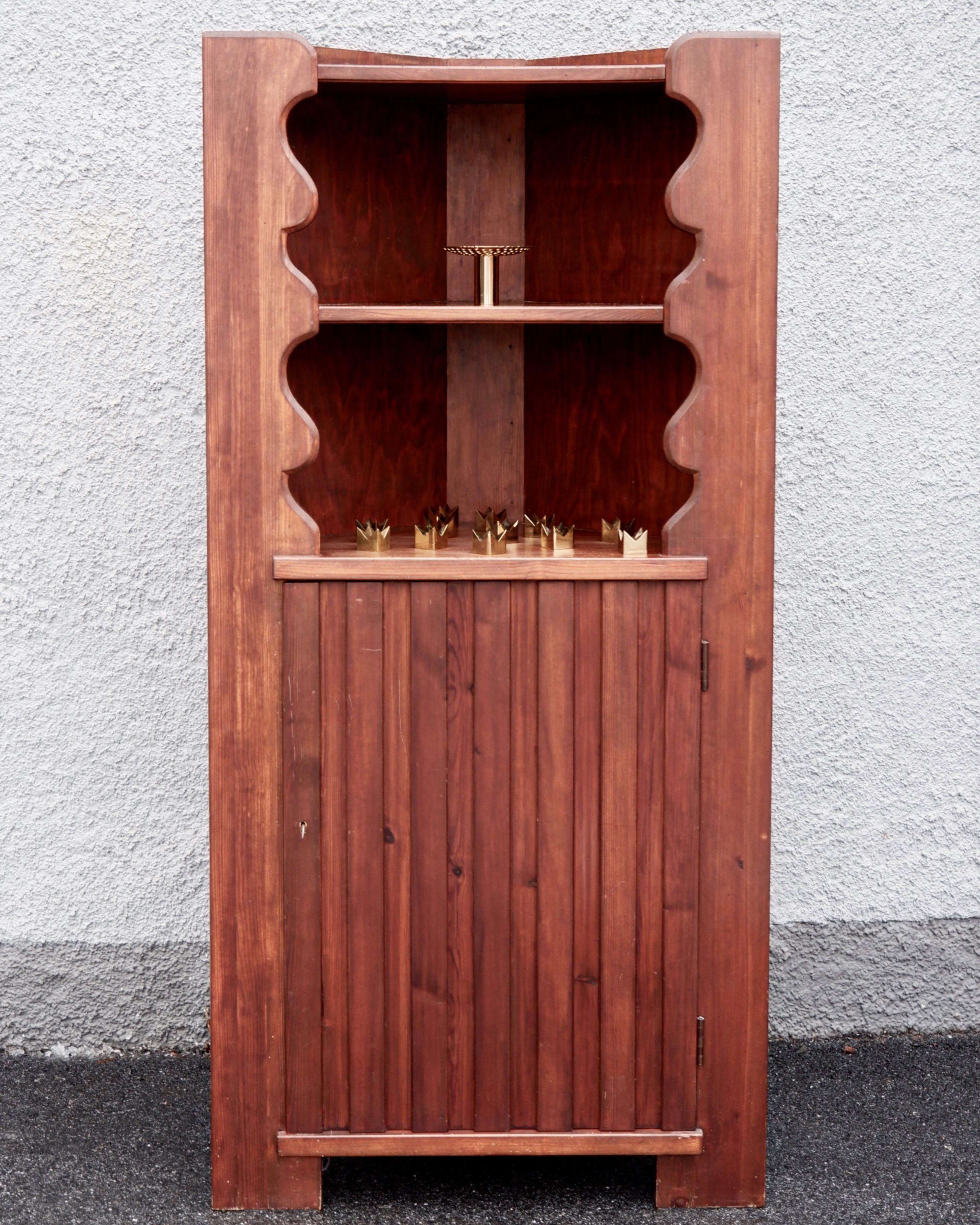 Axel Einar Hjorth pine angle stained cabinet model Utö designed in 1932 and produced by Nordiska Kompaniet in the same time. The cabinet is made in solid pine, has two shelves on the upper part and two other onces in the bottom part. The cabinet can