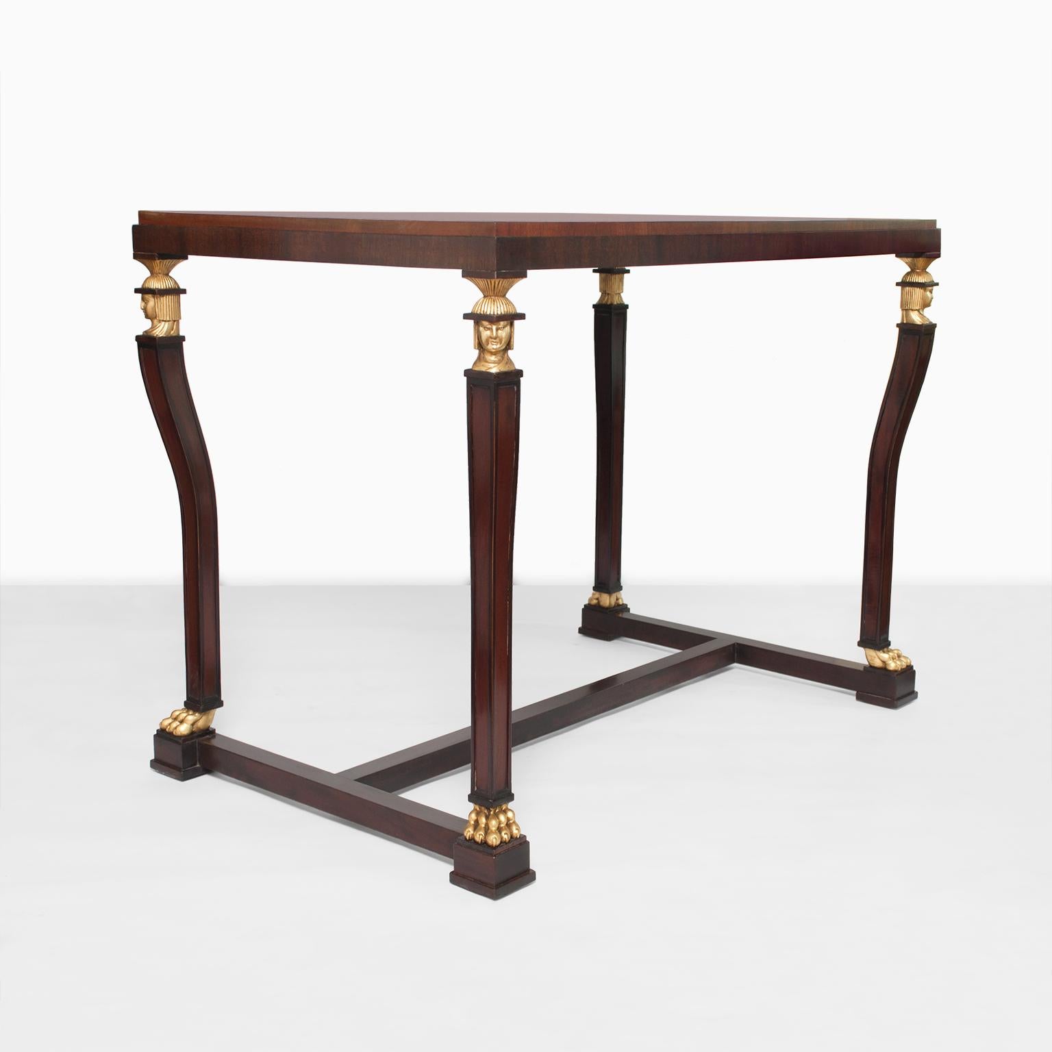 A stunning Axel Einar Hjorth Swedish Grace period (1920- 30) solid mahogany console or center table with carved and parcel gilt Caryatid heads and claw feet. The top is veneered with Cuban flame mahogany. Exceptional quality, fully