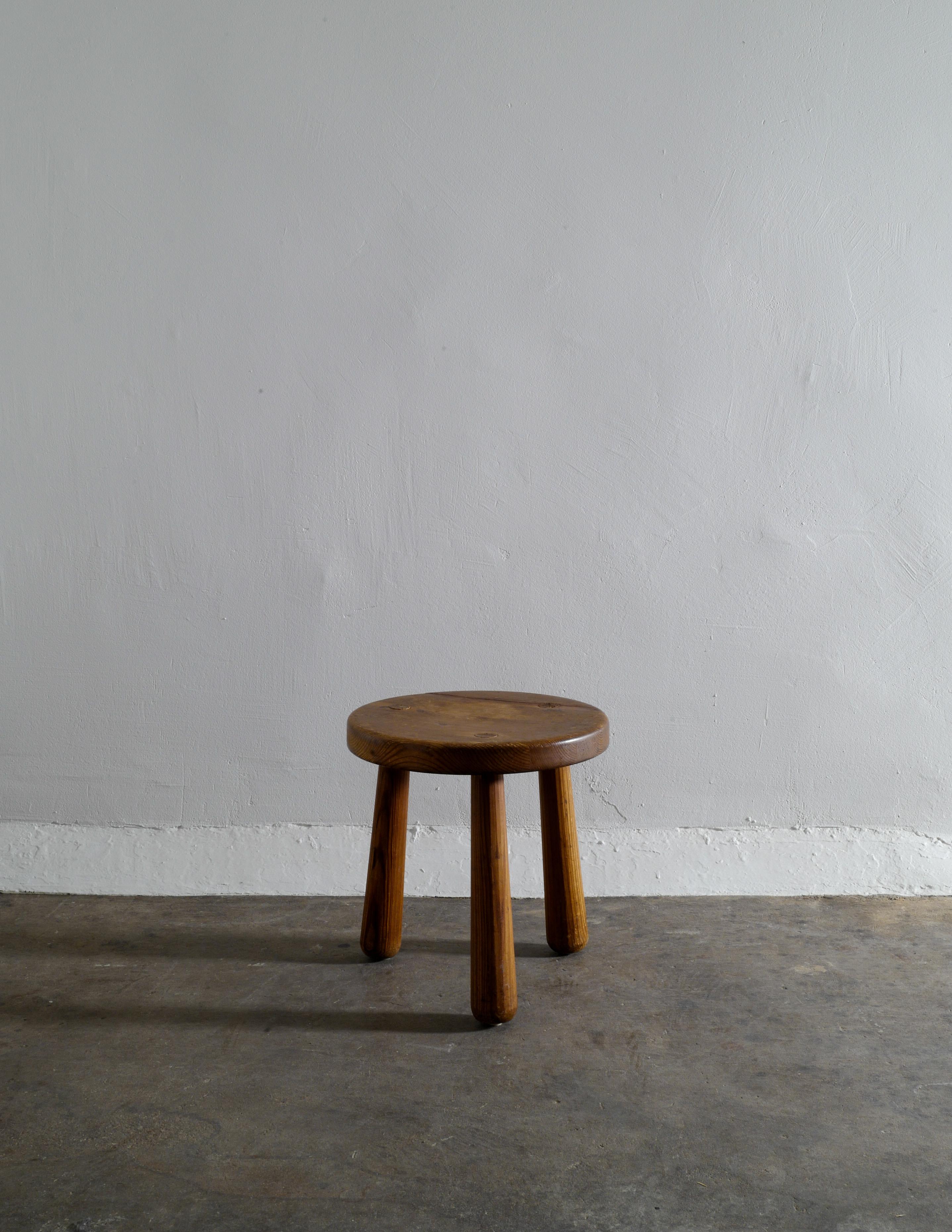 Rare stool in solid pine by Axel Einar Hjorth for Nordiska Kompaniet in Stockholm, 1930s. This stool comes from the original owner family and could have been lowered at some time in the past by ca 4 cm or it was made this way. The stool has the