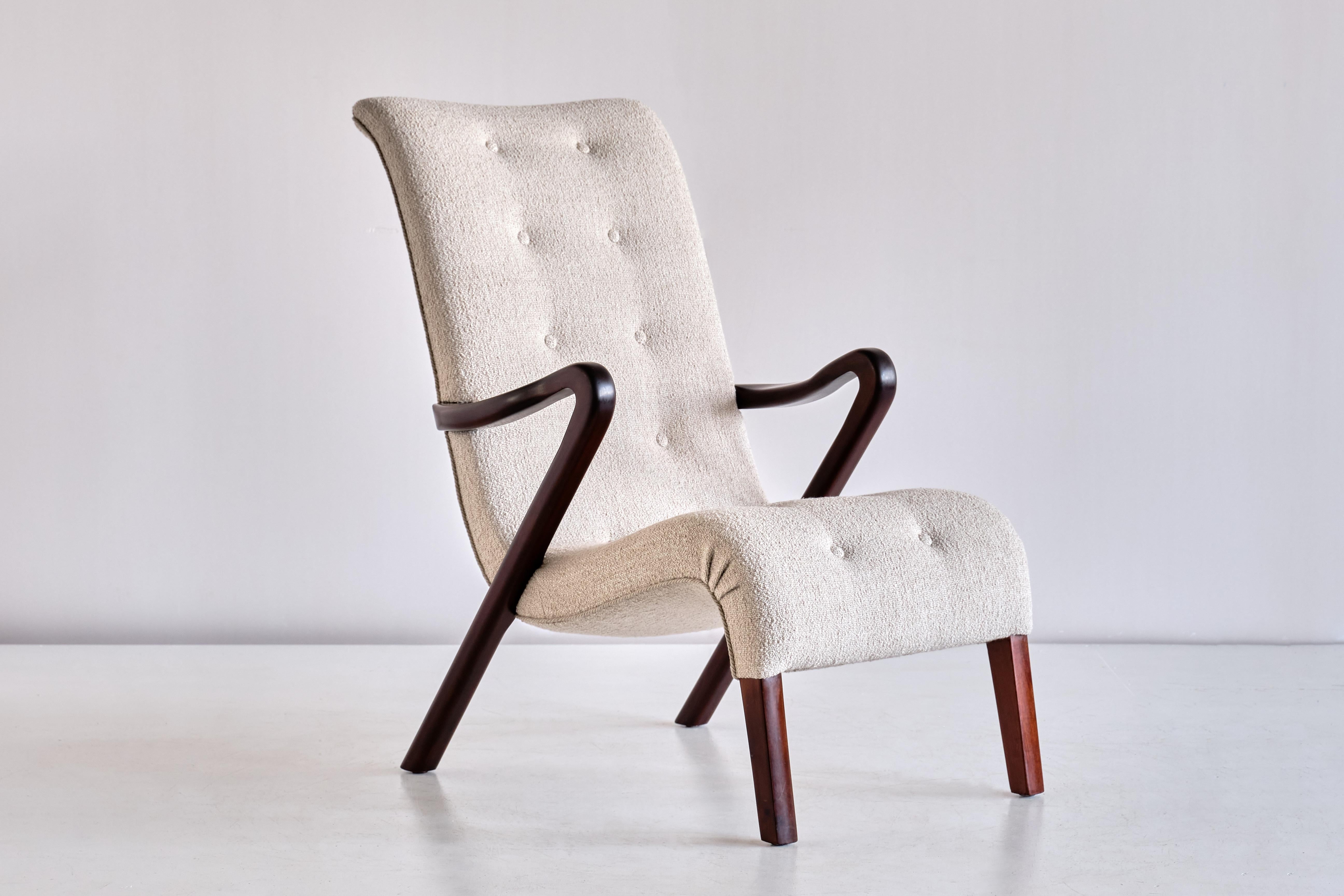 Ce fauteuil rare a été conçu par Axel Larsson et produit en Suède dans les années 1940. Le design élégant et dynamique est formé par la forme incurvée des accoudoirs et du dossier. Les pieds et les accoudoirs sont en bois d'acajou foncé et massif.