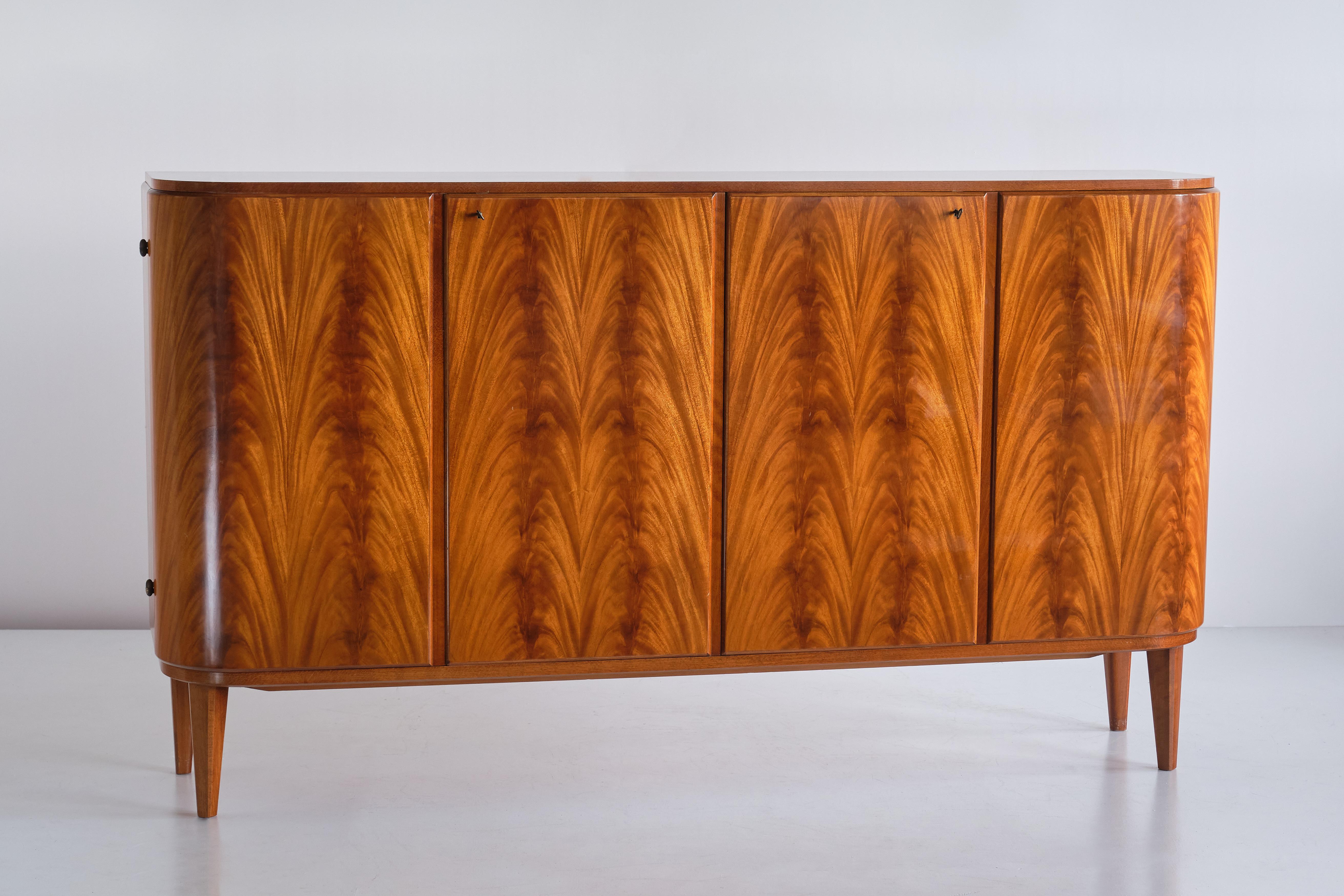 This rare cabinet was designed by Axel Larsson and produced by Svenska Möbelfabrikerna in Bodafors, Sweden in the 1940s. The cabinet has two double doors, all veneered in a pyramid mahogany displaying a beautiful, vivid wood grain. Interior with