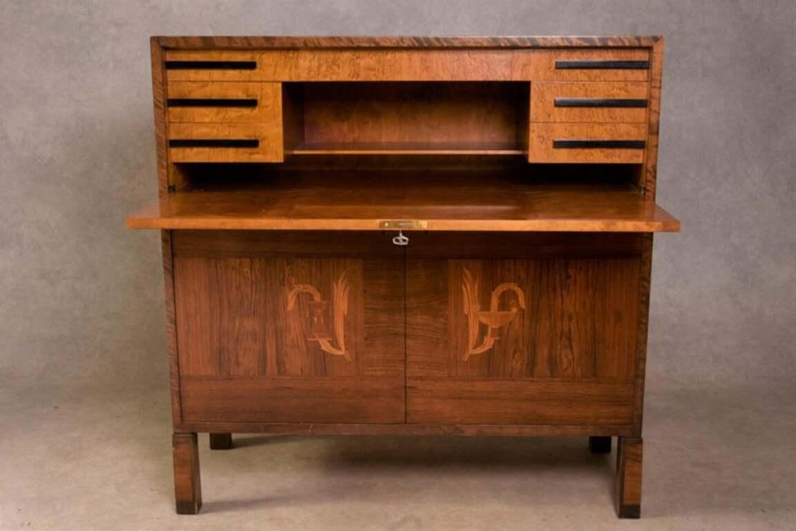 Dieser Schrank der schwedischen Moderne wurde von Axel Larsson (1898-1975) entworfen. Sie hat eine herunterklappbare Schreibklappe und ist mit einem Schloss und Schlüssel versehen (Schlüssel im Lieferumfang enthalten). Der Schrank besteht aus