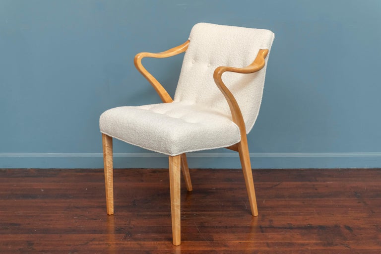 Axel Larsson design armchair for Bodafors, Sweden. Made with a solid birch wood sculpted frame with and interesting design arm that has just been newly strengthened and refinished. New boucle upholstery and ready to install.