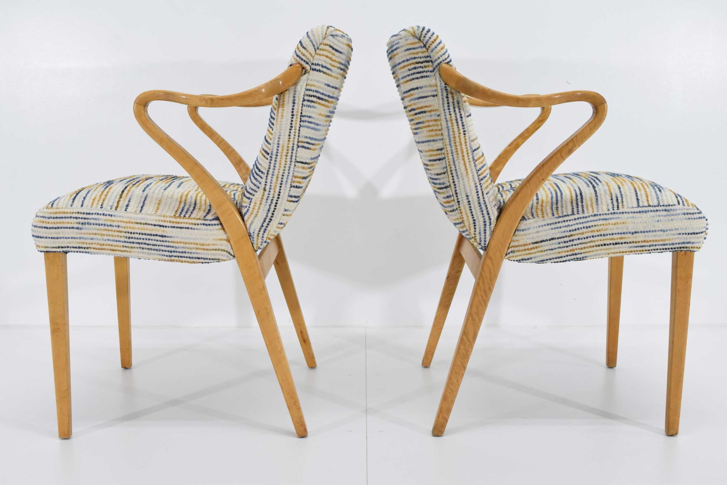 A pair of tiger eye birch model 1522 armchairs with wonderfully curved armrests by Axel Larsson for Svenska Möbelfabrikerna, Bodafors. This model was designed in 1936. We have reupholstered in a bouclé Pollack fabric with blues, gold, nutmeg that