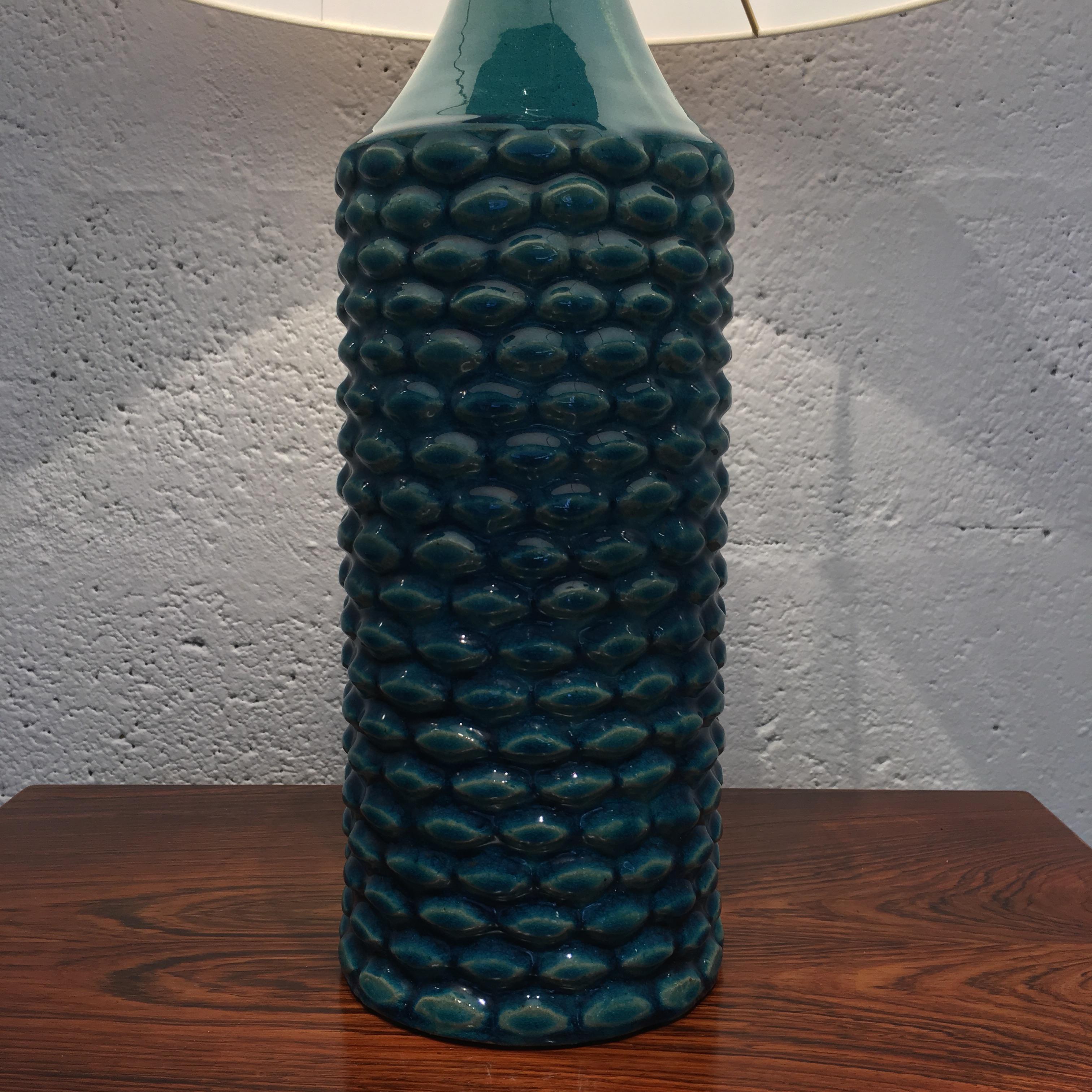 Axel Salto, a Royal Copenhagen stoneware table lamp, modelled in budded style, decorated with rare celadon blue-green glaze from 1969.
Measures: 63 cm high with shade.