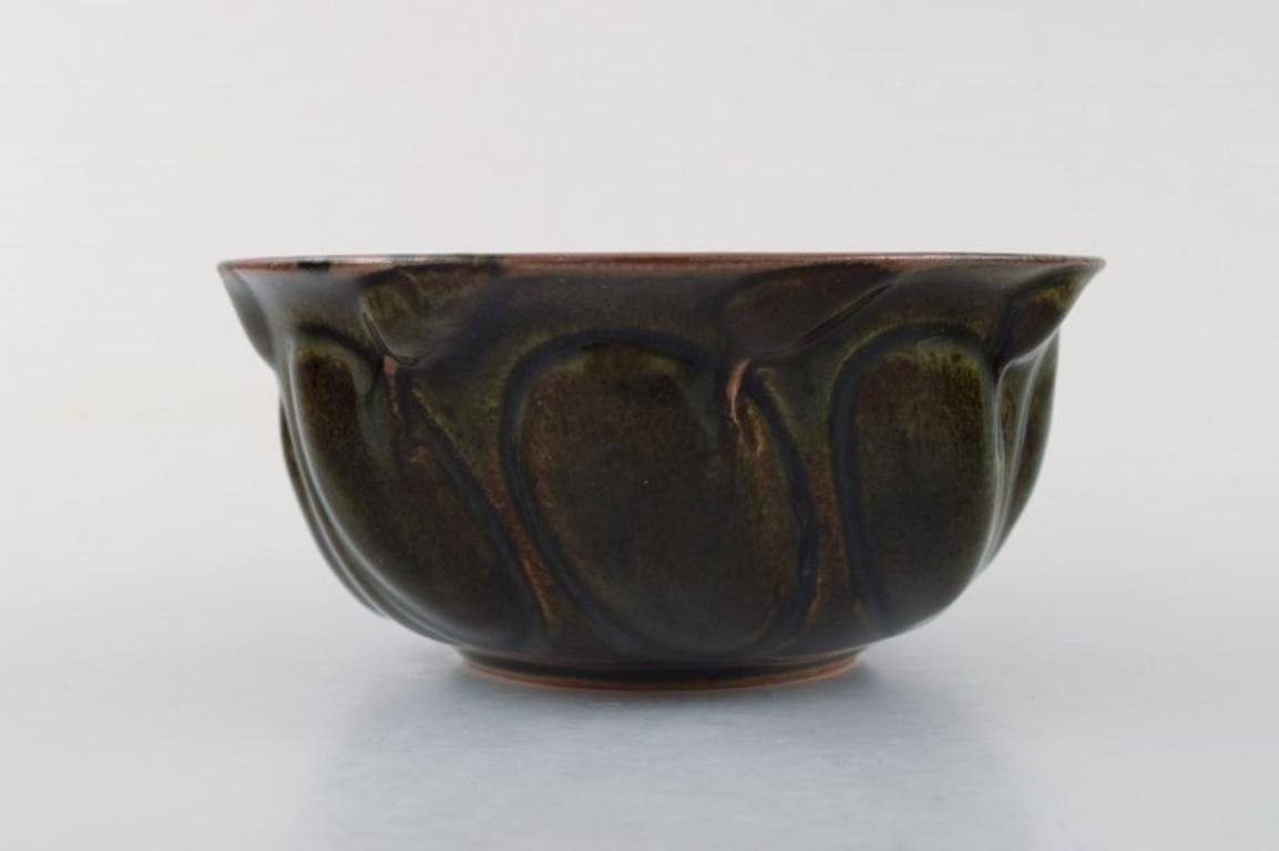 Axel Salto for Royal Copenhagen.
Stoneware bowl, modelled in organic form, decorated with glaze in aubergine-coloured tones. 
Signed Salto. Stamped and dated 1958
In perfect condition. 3rd factory quality.
Measures 15 cm. X 7 cm.
