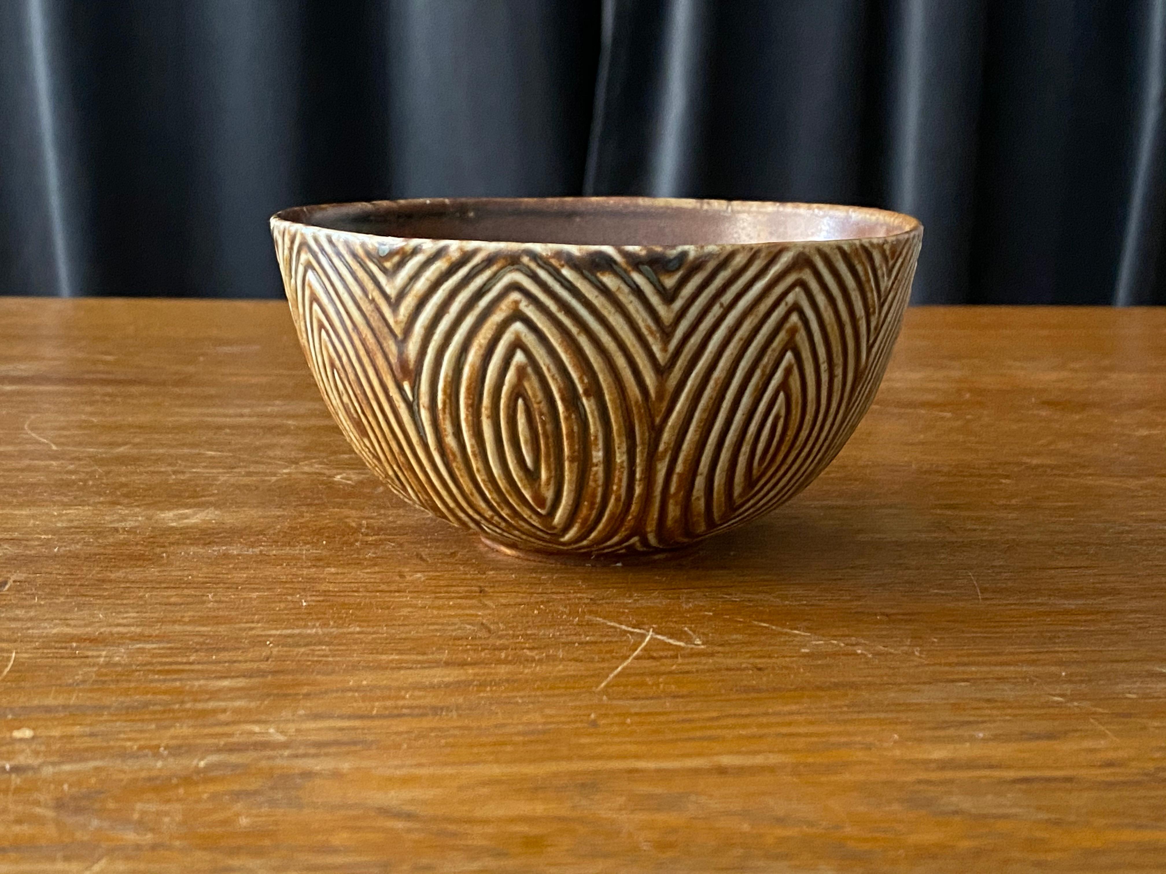 A rare small decorative bowl. Executed in stoneware with a highly ornamented stylized relief and glaze iconic to Salto. Brown and beige. Marked with the Royal Copenhagen mark and signed.

Other ceramicists of the 20th century include Claude