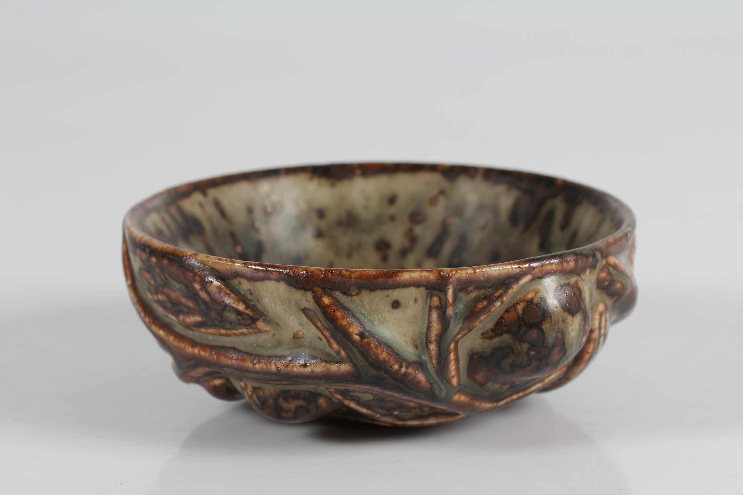 Small Bowl model no. 20677 designed in 1944 by Axel Salto (1889-1961) 
The stoneware bowl has a modeled relief of twigs with fruits and leaves decorated with sung glaze.

Sign: Salto + 3 blue waves for Royal Copenhagen

Nice condition without