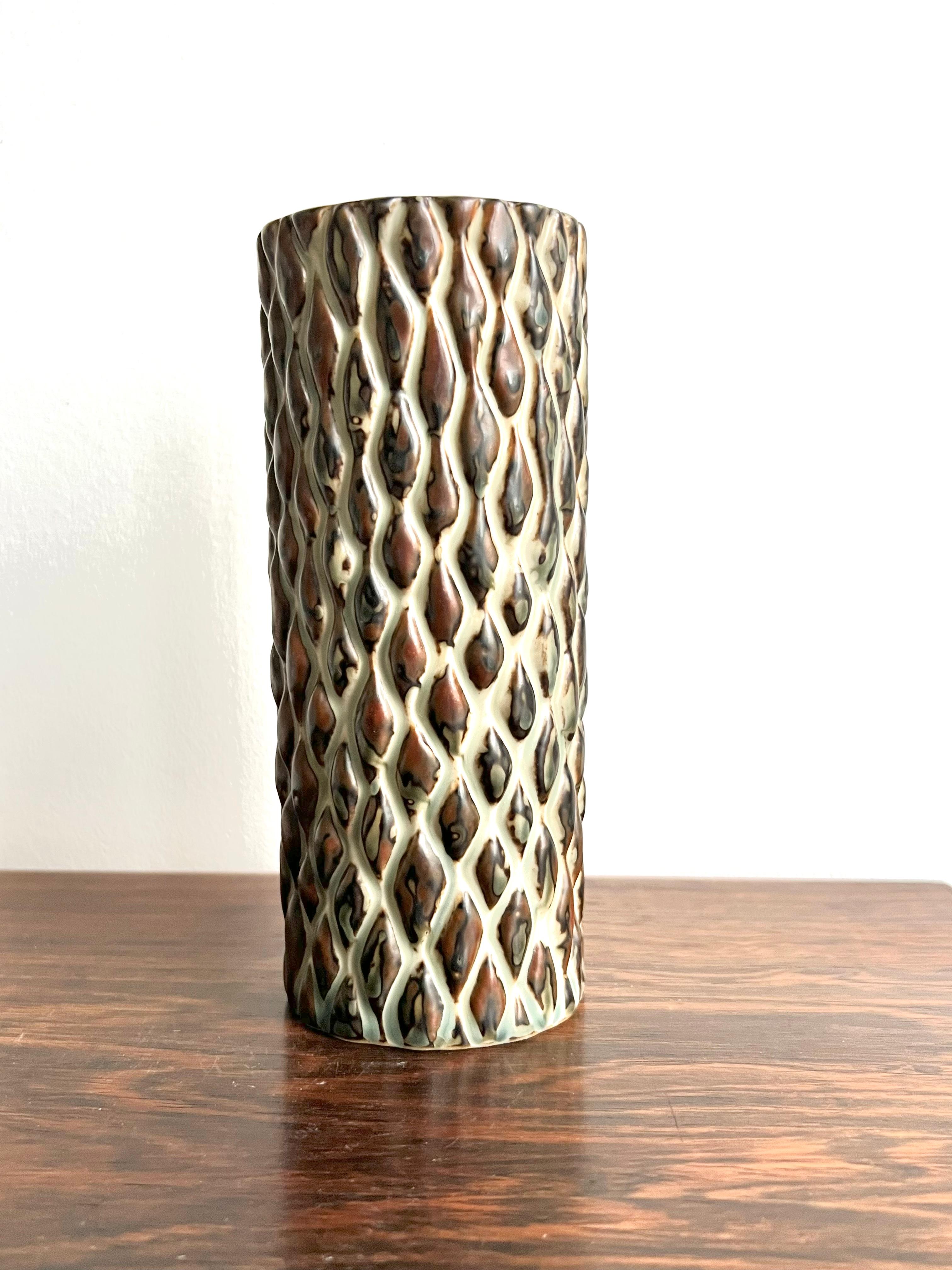 Axel Salto, a peppled style vase for Royal Copenhagen, produced in the 1970’s, but designed pre 1950. The vase is covered with a darkbrown “Sung glaze” from Royal Copenhagen. He used the cylinder shape for many of his vases and added various