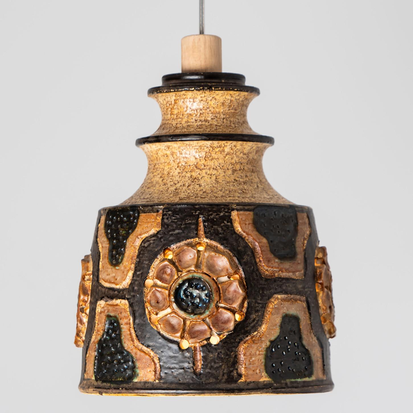 Wunderschöne runde Hängelampe mit einer ungewöhnlichen Form, hergestellt aus farbenprächtiger brauner Keramik, hergestellt in den 1970er Jahren in Dänemark.

Mit schönem, zerbrechlichem Stahlseil und hölzernen Details. An einem Stahlseil hängend