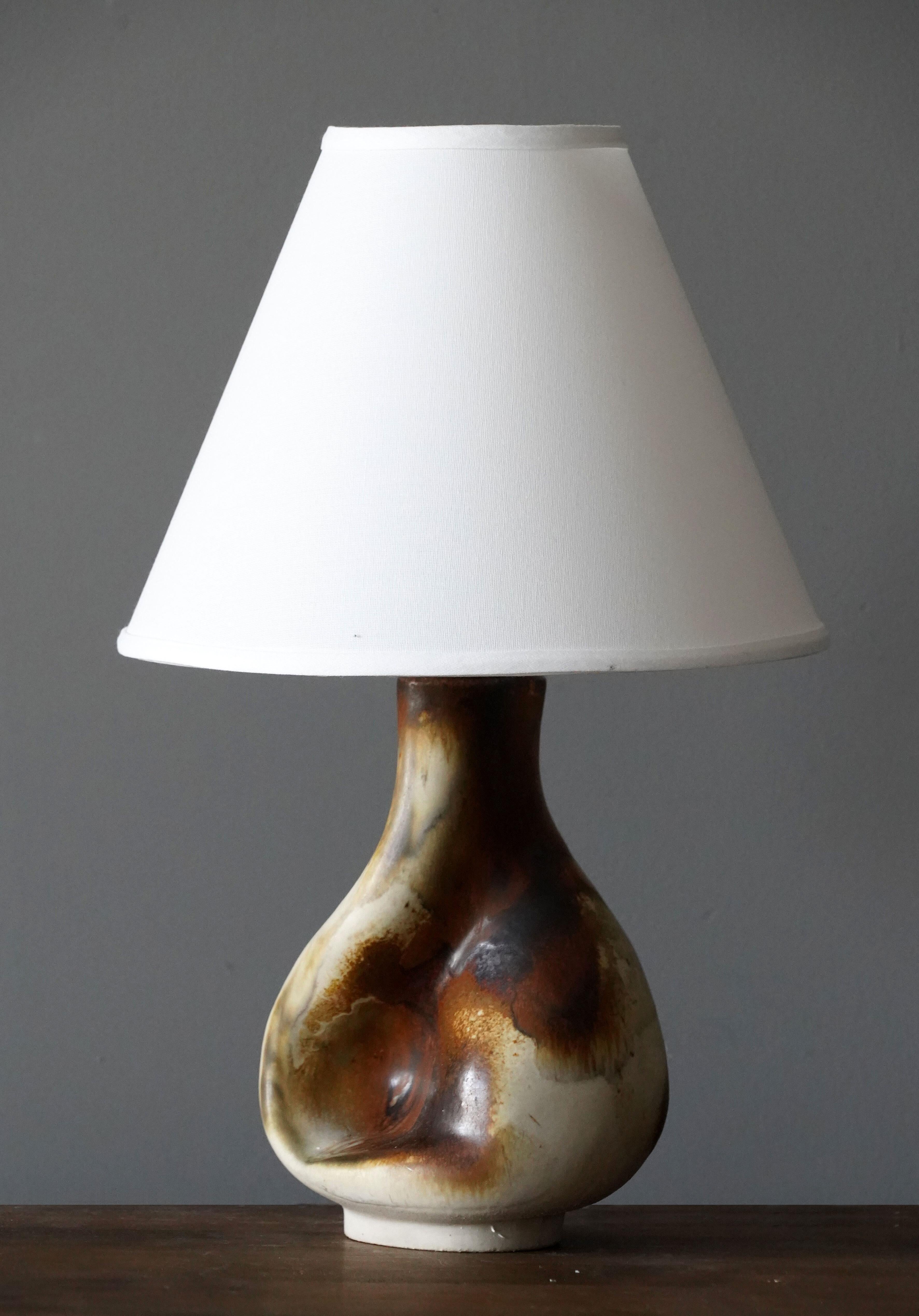 A table lamp produced and designed by Axella, Denmark, 1960s. With makers label.

Lampshade is attached for reference and are not included in the purchase. Measured without lampshade.

Glaze features brown-beige-green colors.

Other ceramicists of
