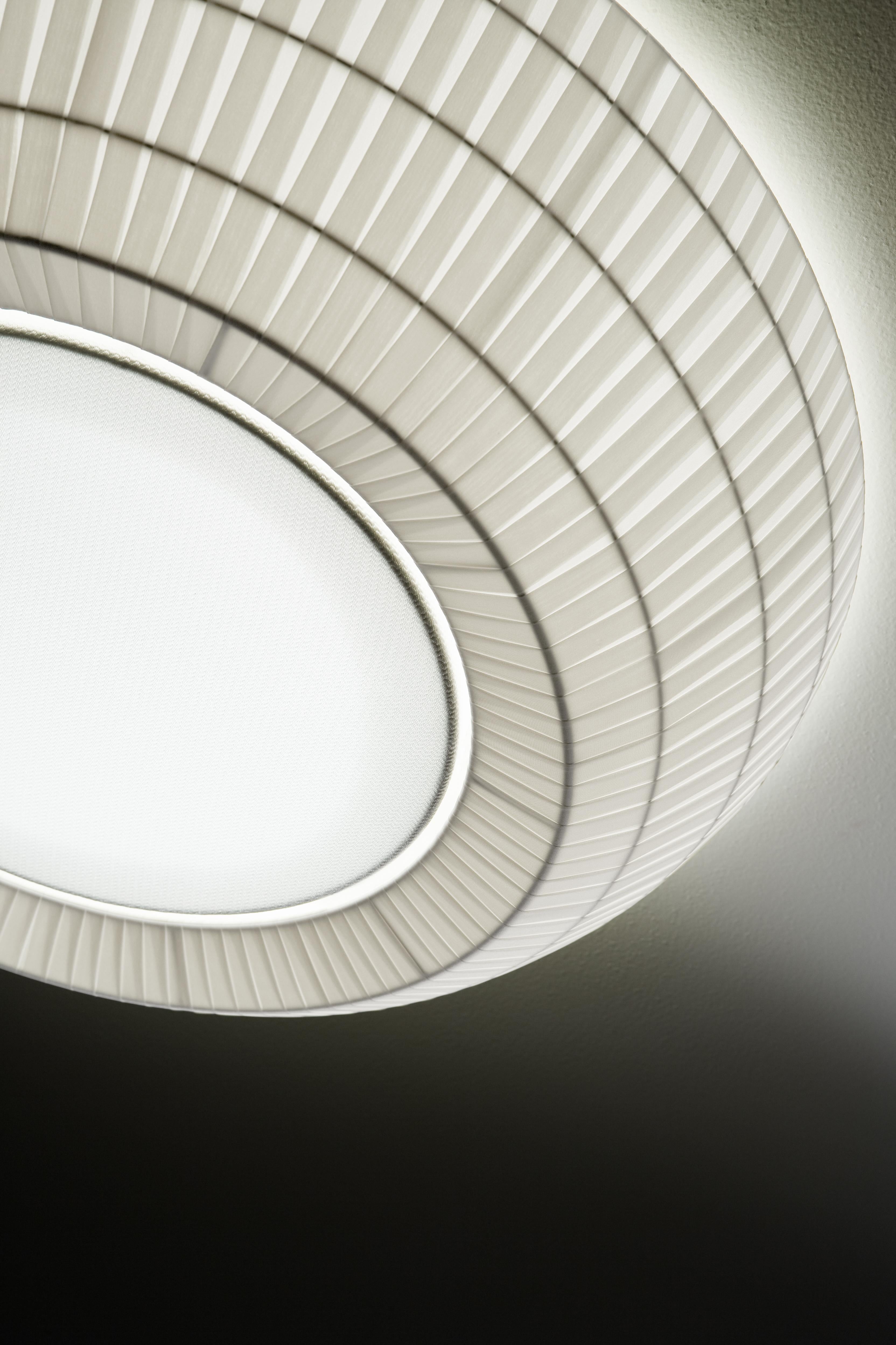 Axolight Bell Large Flush Mount/ Ceiling Lamp in Warm White by Manuel & Vanessa Vivian

The ceiling version of Bell is in continuity with the aesthetic of the pendant one. The lightness given by the fabric, the multidimensionality and the chromatic