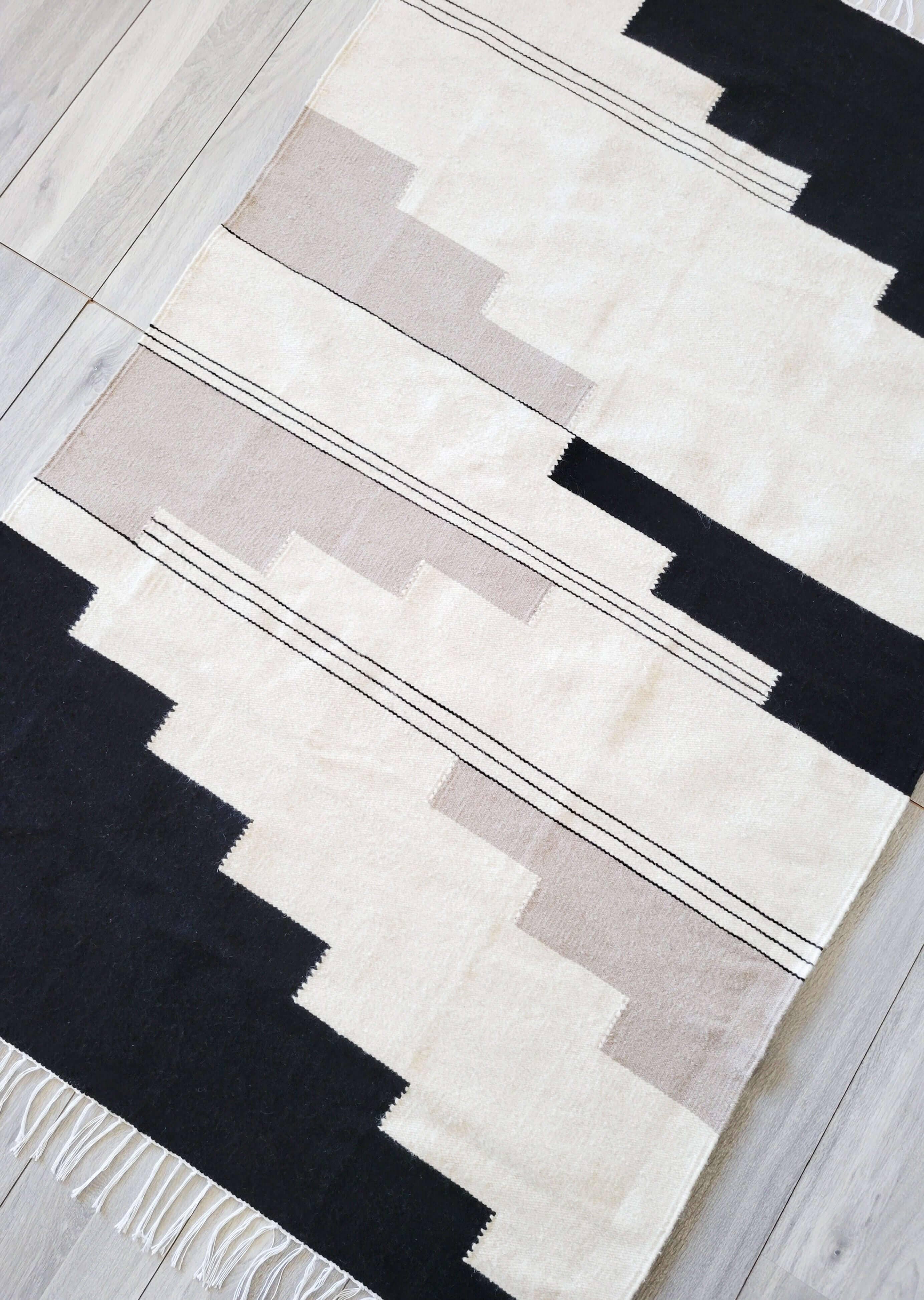 Dieser Teppich aus natürlicher Wolle ist in den Farben Schwarz, Grau und Creme gehalten und besteht aus 100 % Wolle. Er ist strapazierfähig, weich und perfekt für jeden Raum im Haus. Neutrale Farben ermöglichen eine einfache Anpassung an jede
