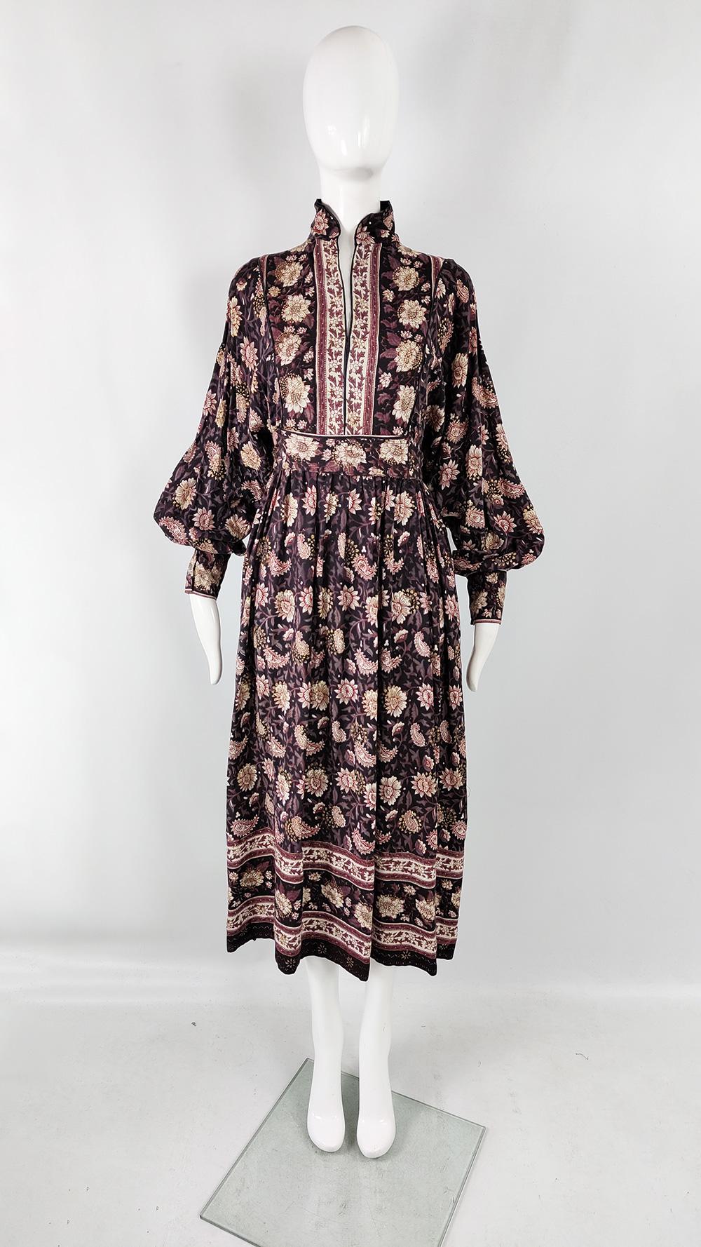An incredible vintage womens dress from the 70s by luxury British-Indian fashion designer, Ayesha Davar. In a soft and drapey rayon fabric with an Indian block print throughout and subtle gold painted details adding a luxe touch. It has voluminous