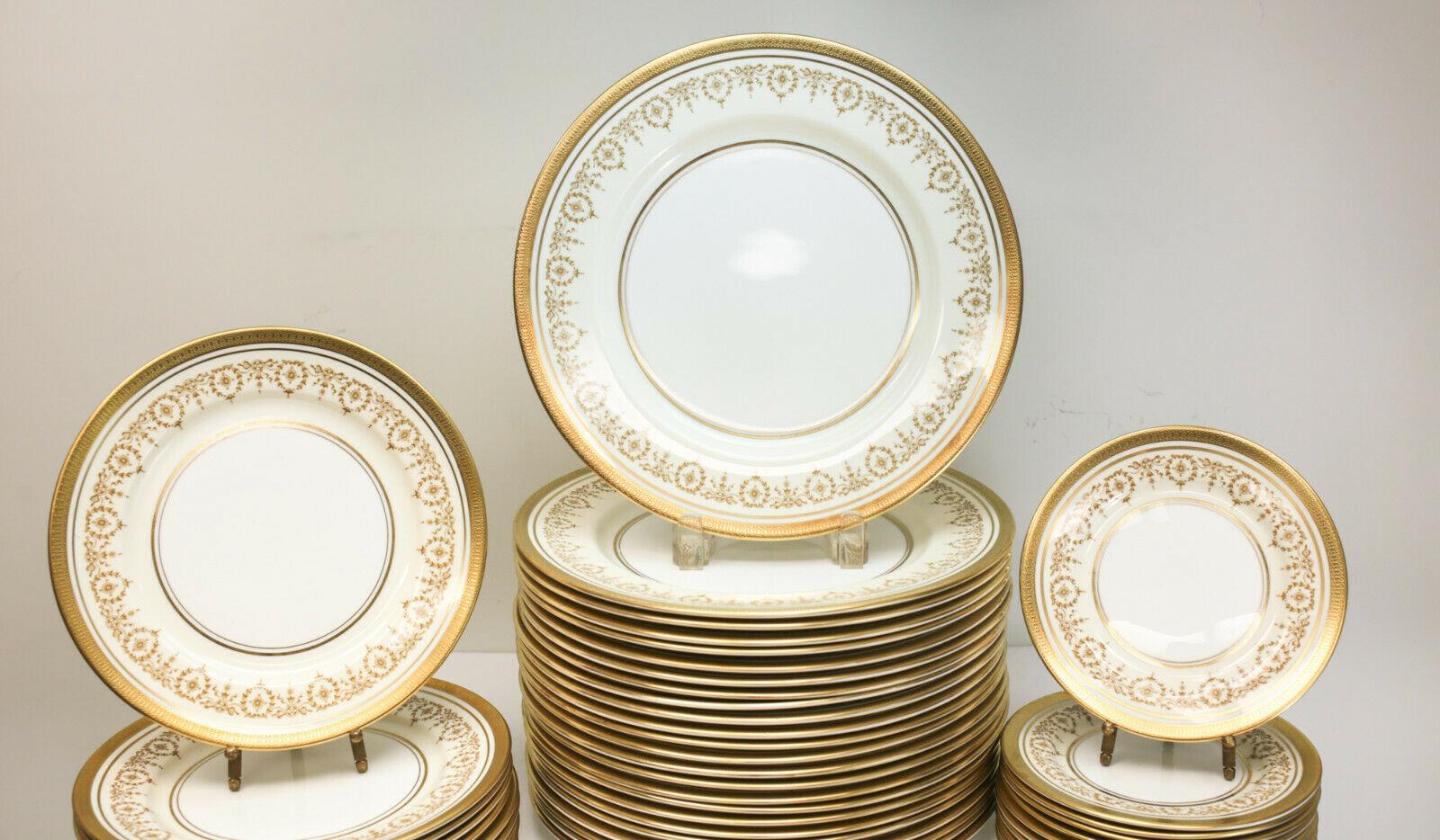 Aynsley bone china porcelain dinner service for 12 in gold Dowery, circa 1960. Gilt trim to the edges with gilt ribbons to the inner rim. Aynsley mark to the underside. The service comes with 11 salad plates, 12 bread and butter plates, 24 dinner