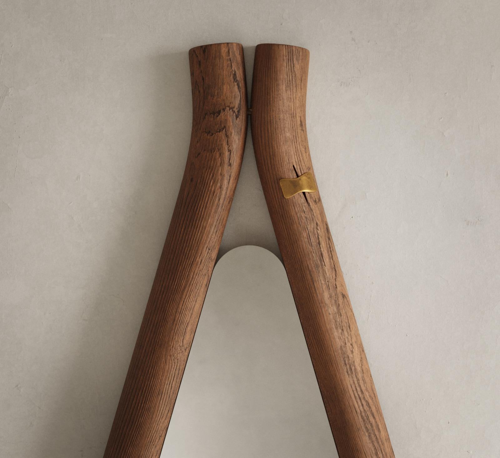 Le miroir de sol Ayo est un meuble artisanal qui combine le bois massif et le bronze liquide pour un aspect unique. Le miroir est fabriqué à l'aide de techniques traditionnelles telles que l'artisanat et le moulage, ce qui garantit que chaque pièce
