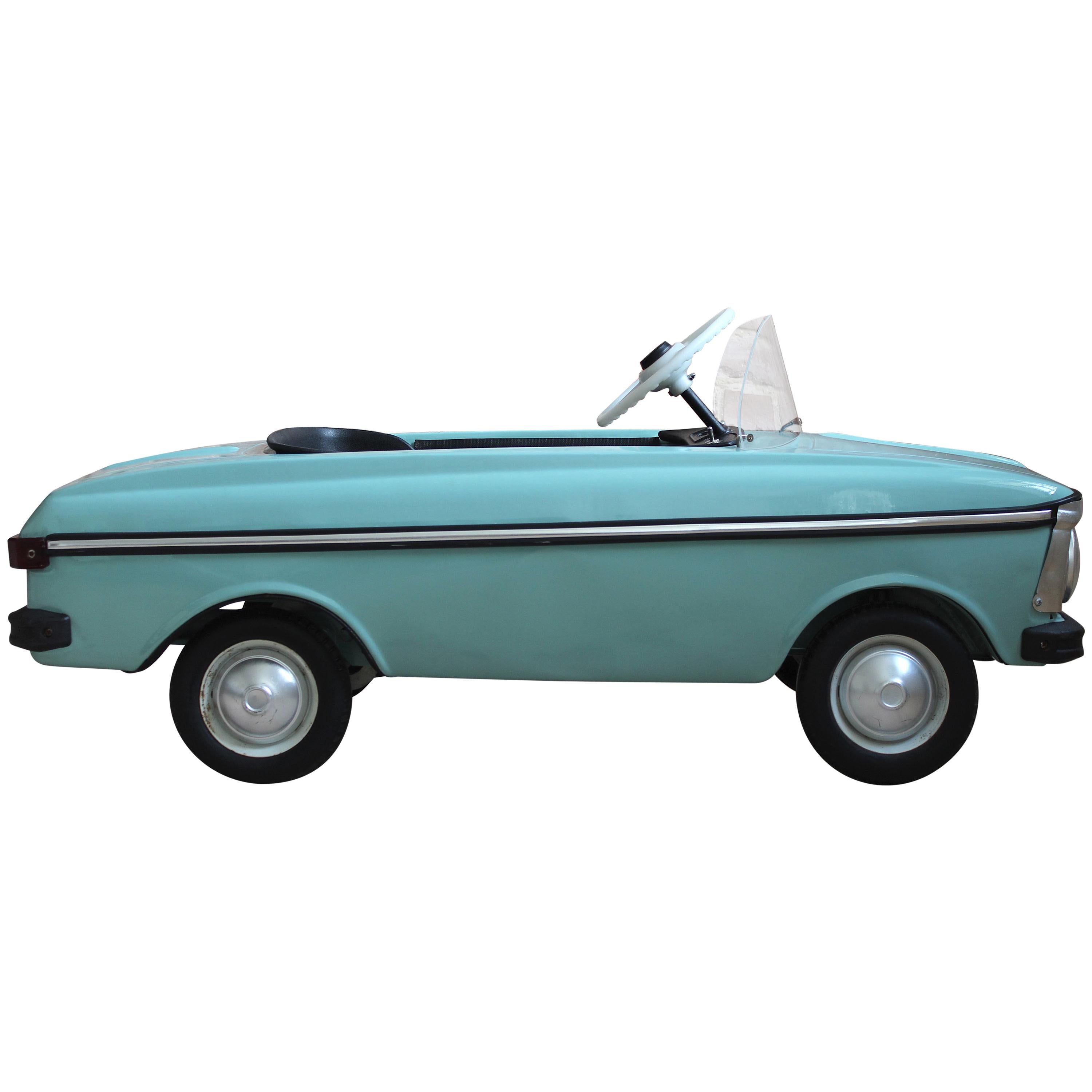 This early Soviet child's pedal car was manufactured during the communist era in former Czechoslovakia. It was created as a model for children as a small copy of the original Moskvich car and works on a pedal moving system. The piece features fully