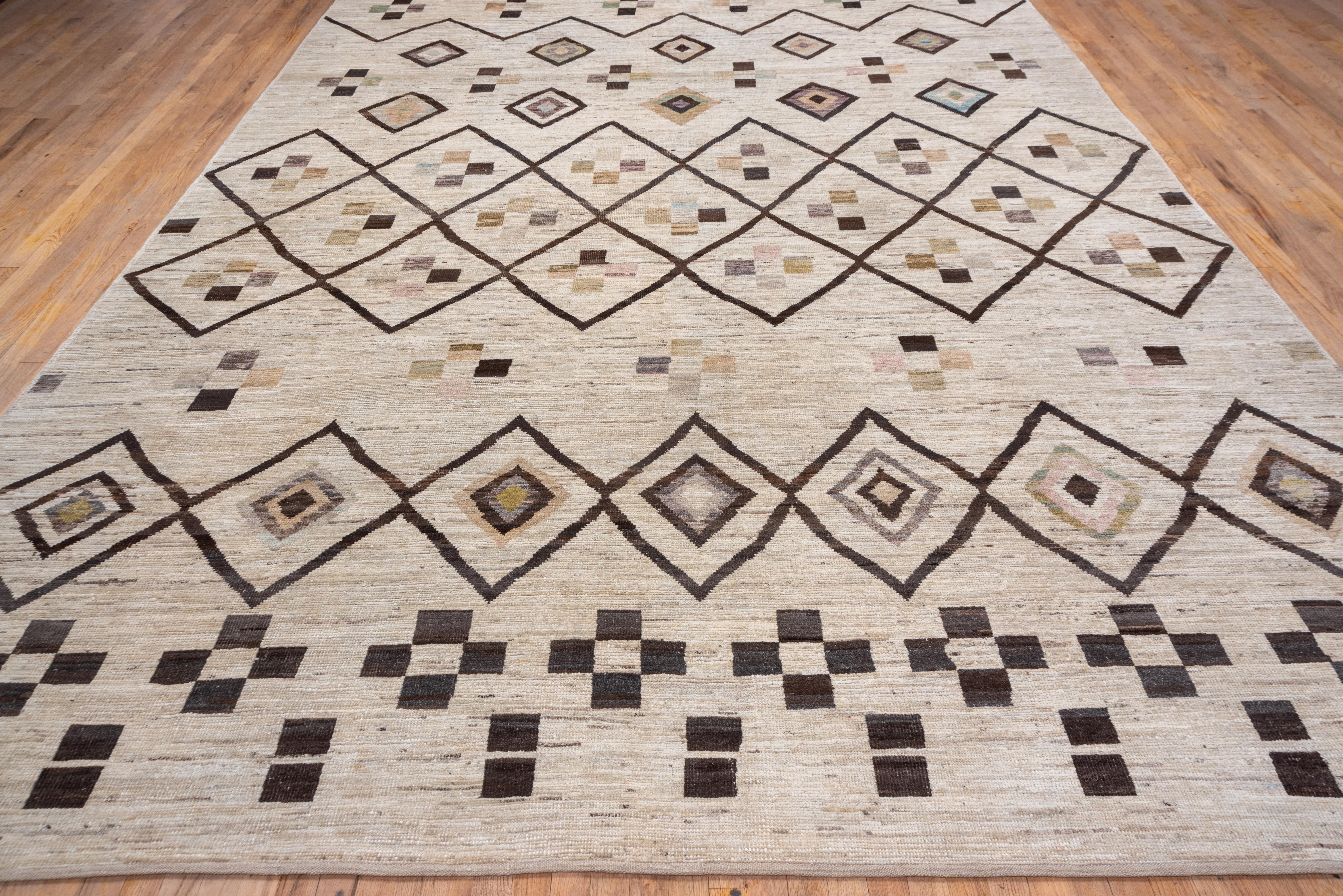 This Azilal-style rustic tallish pile room size shows a nested lozenge lattice, and small floating diamond design, with rows of ornaments of small squares. Sand ground with dark brown and lighter accents.