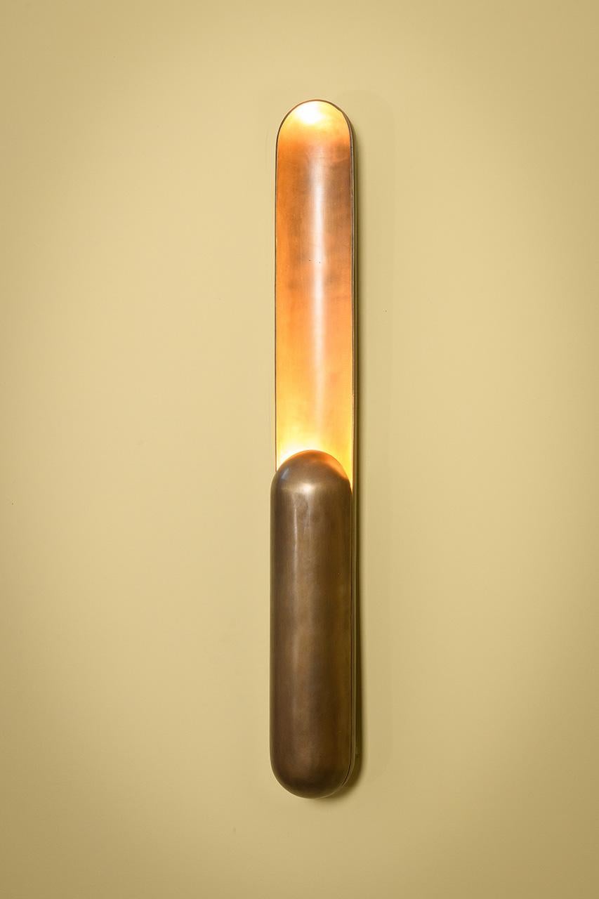 Azo nace de la intención de crear un atril con iluminación vertical.
Su forma es el resultado de un corte longitudinal en un cilindro con extremos redondeados,
con la longitud reducida en un lado para resguardar la fuente de luz. 
La iluminación, a