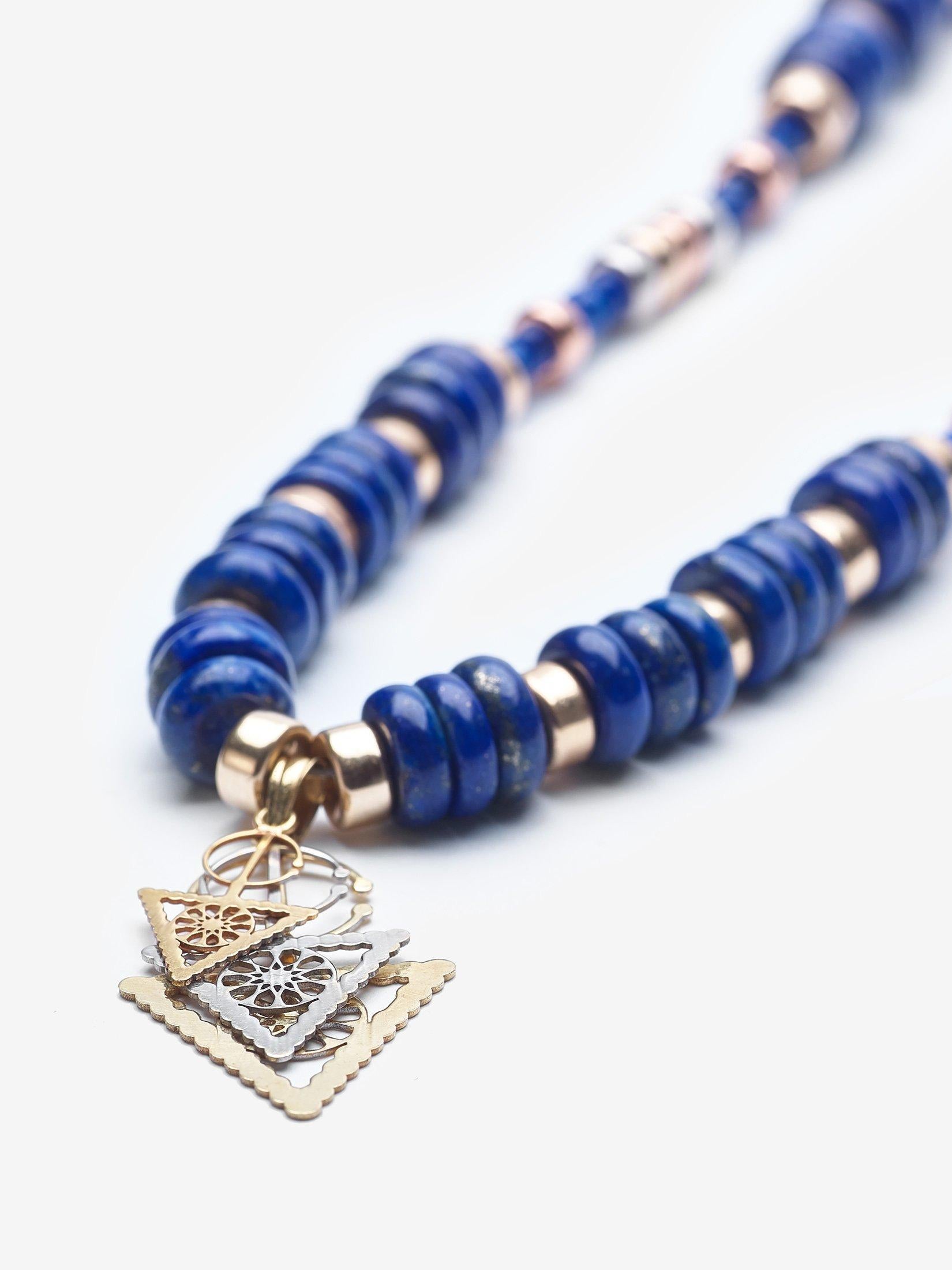 The necklace features a 14K gold, rose gold and silver Berber compass pendant from the souks of Fez, Morocco. The necklace is adorned with large lapis stones that are a celestial blue.  The necklace was handmade in Newport Beach, California.  Blue
