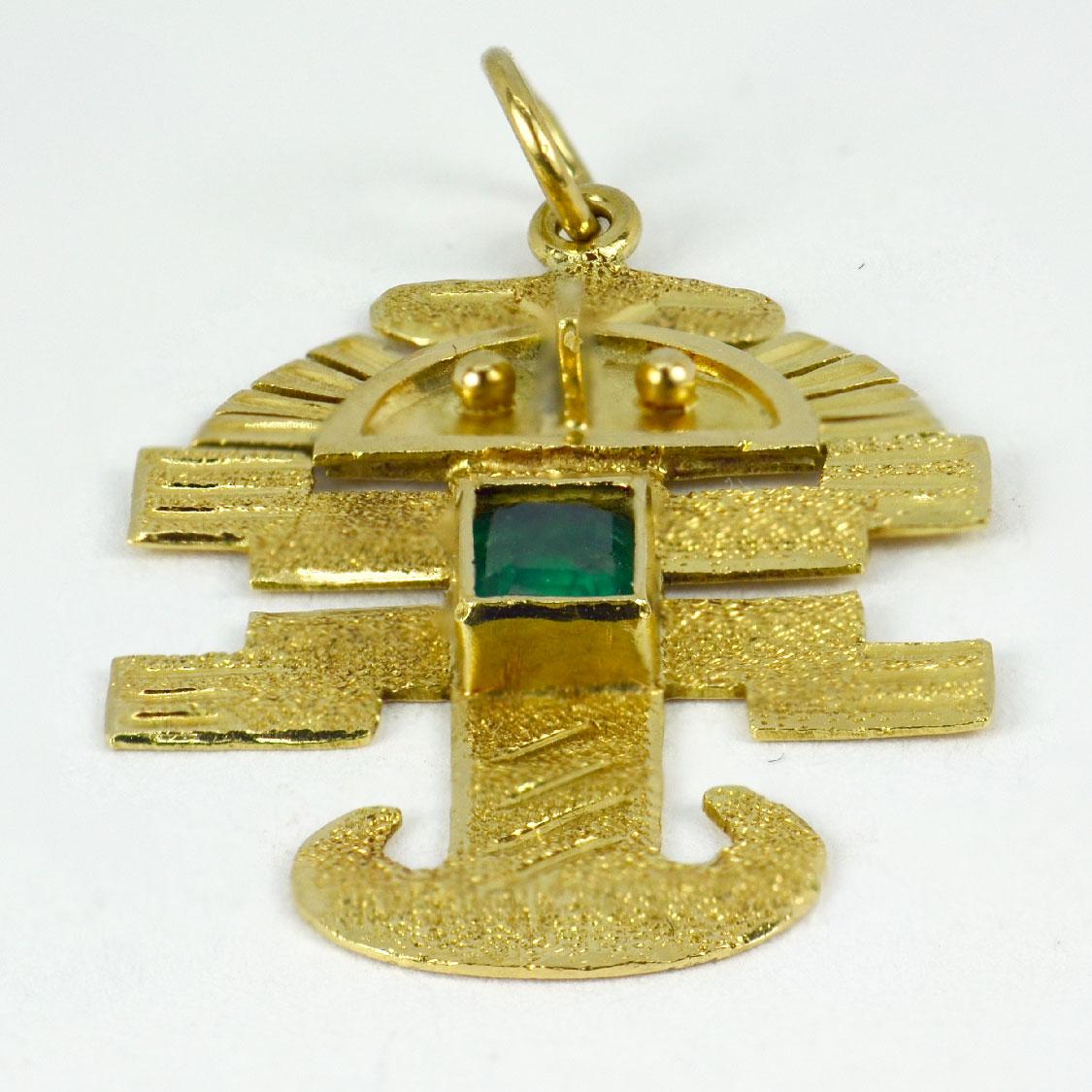 An 18 karat (18K) yellow gold charm pendant designed as an Inca god or icon set with an emerald cut emerald with an estimated weight of 0.27 carats. Unmarked but tested for 18 karat gold.

Dimensions: 3.1 x 1.9 x 0.25 cm (not including jump