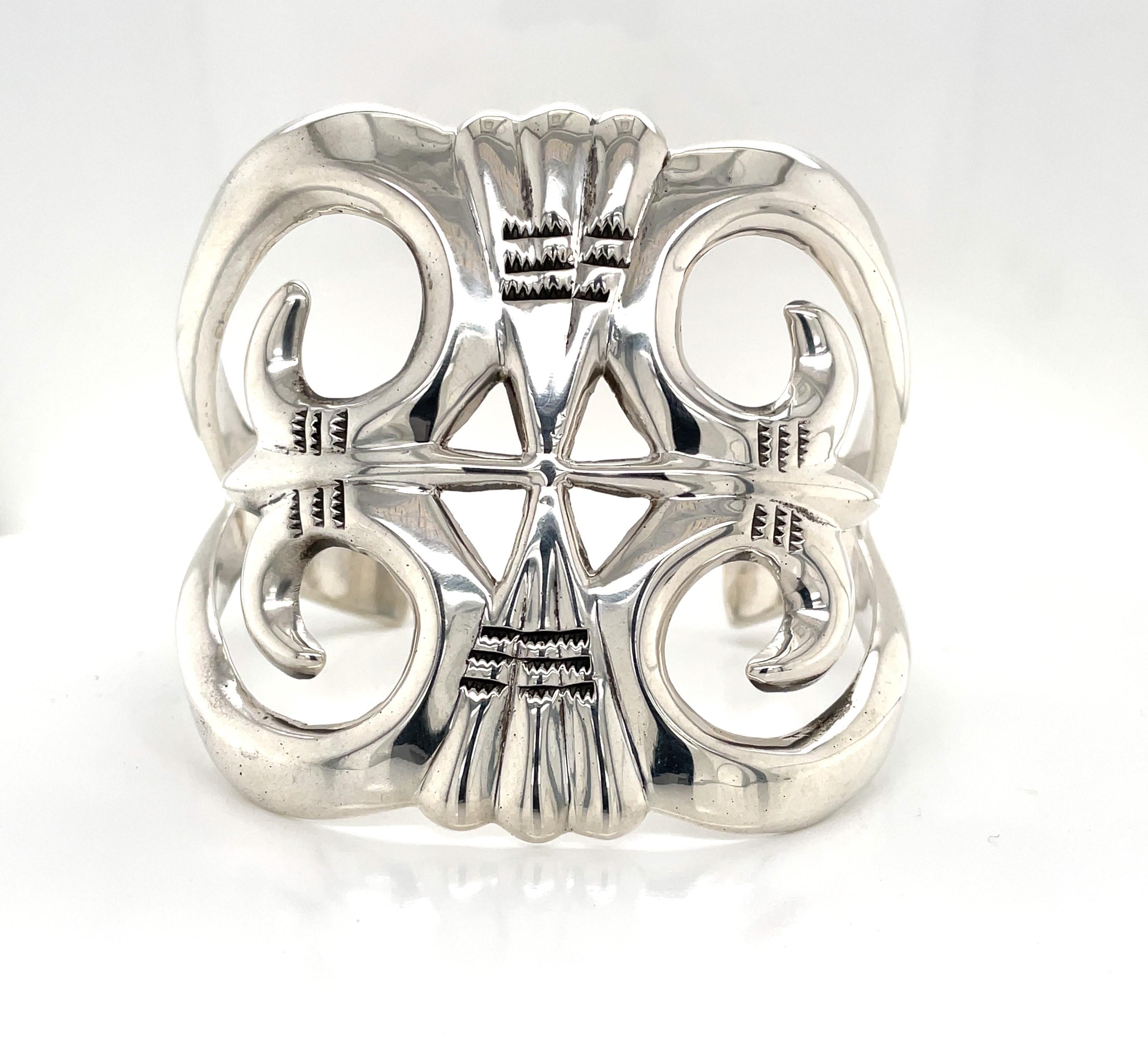 Kühn im Design und von beträchtlichem Gewicht in .900 Silber gefertigt, zeigt dieses fein gearbeitete Manschettenarmband ein attraktives aztekisches Design mit einer großzügigen Breite von 2-3/8 Zoll. Dieses große Statement-Armband misst 2-3/8 Zoll