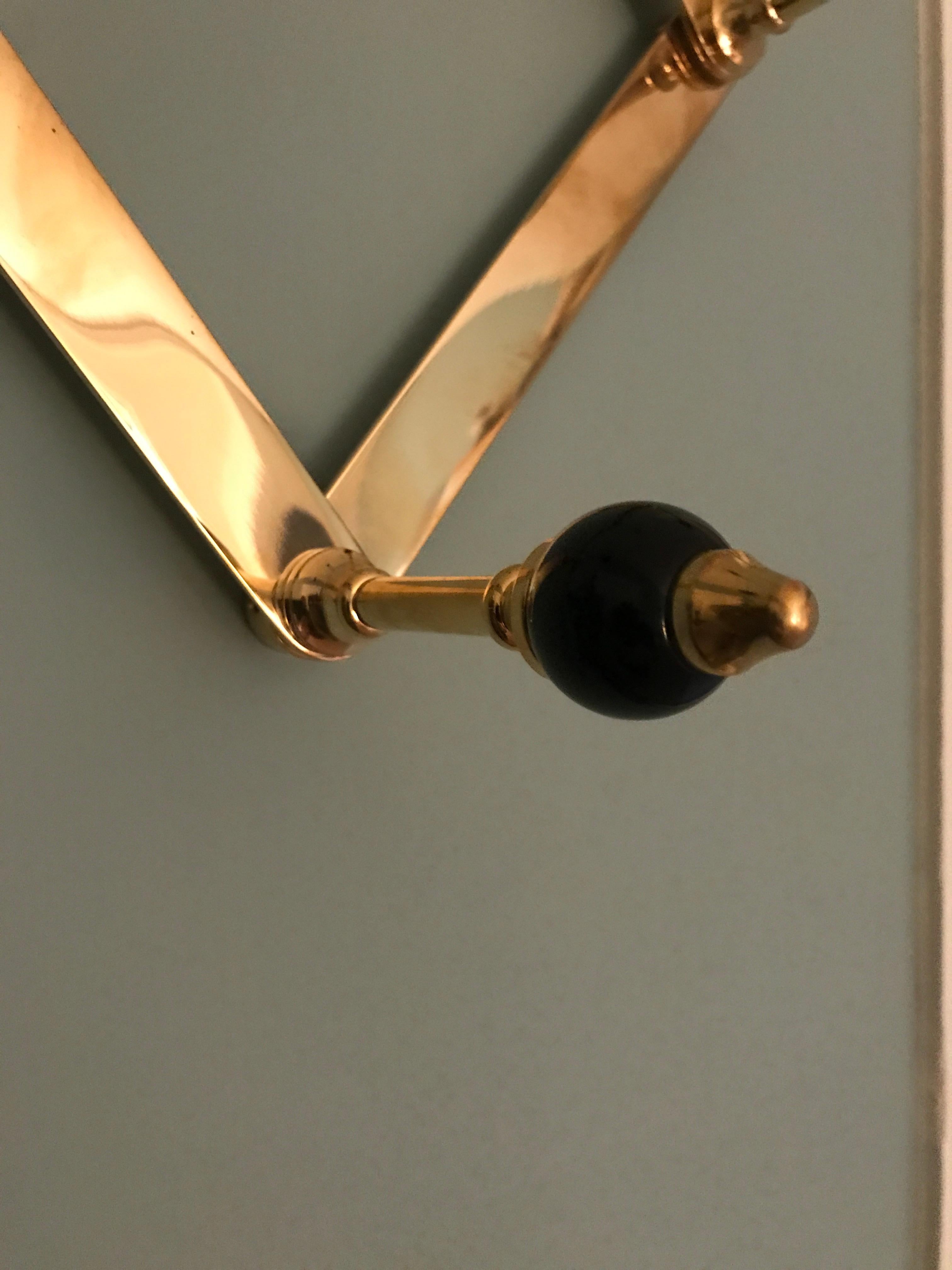 Elegant coat hanger in polished brass and black lacquered wooden knobs. Designed by Luigi Caccia Dominioni in the 1960s for Azucena.
