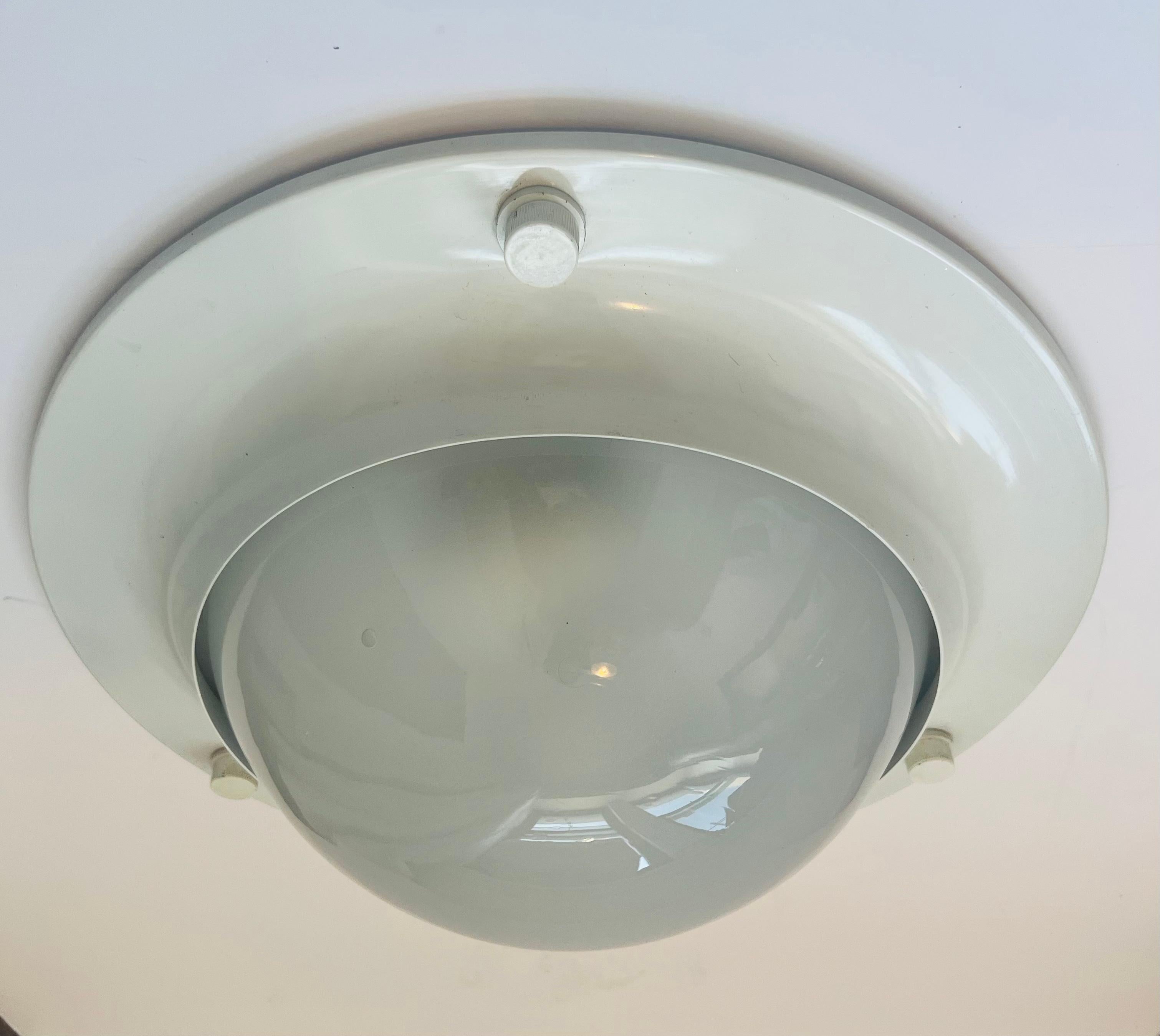 A 1960s Italian Mid Century Nautical Space Age Style flush ceiling lamp done in a white enamel frame with a white dome glass shade. Two 100 watt light sockets. Rewired 