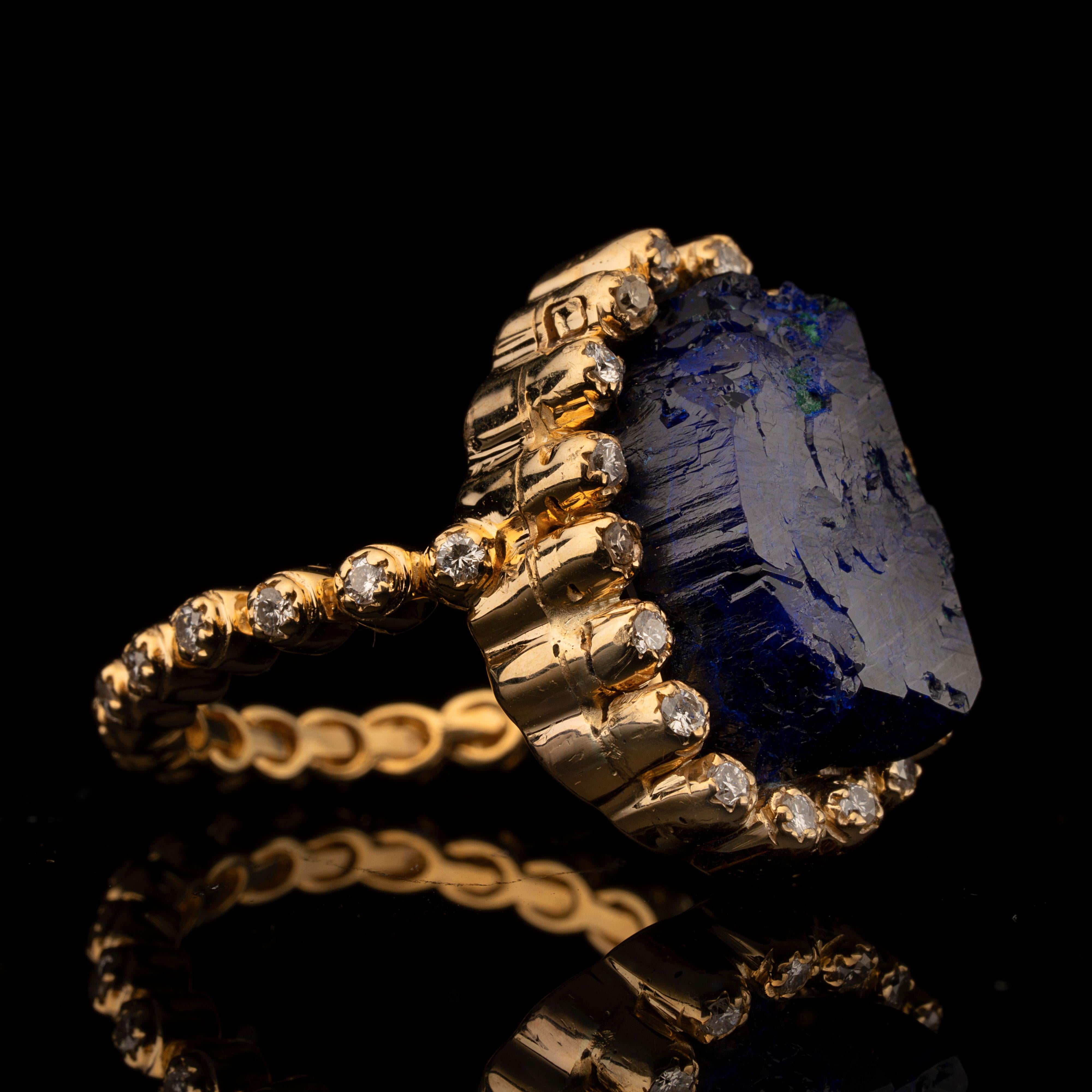 Questo splendido anello personalizzato unico nel suo genere mette in mostra un'azzurrite grezza di grandi dimensioni con tracce di malachite vivida in una montatura smerlata in oro 14K rivestita da 38 diamanti a taglio rotondo intorno alla fascia e