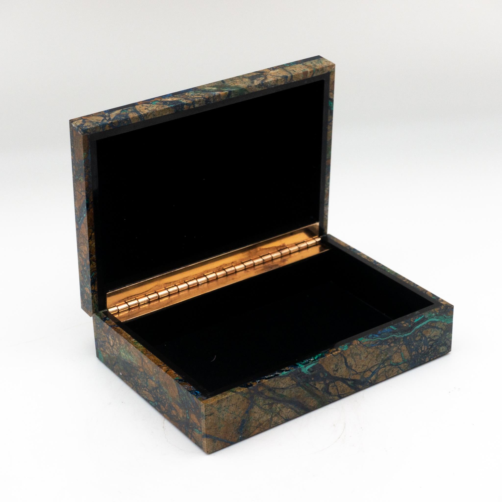 Azurite box with hinged lid featuring distinctive streaks of blue, black and brown. 

Azurite is a highly sought after crystal in the world of gemstones, Azurite is known for its stunning blue color, which evolved over the millennia through