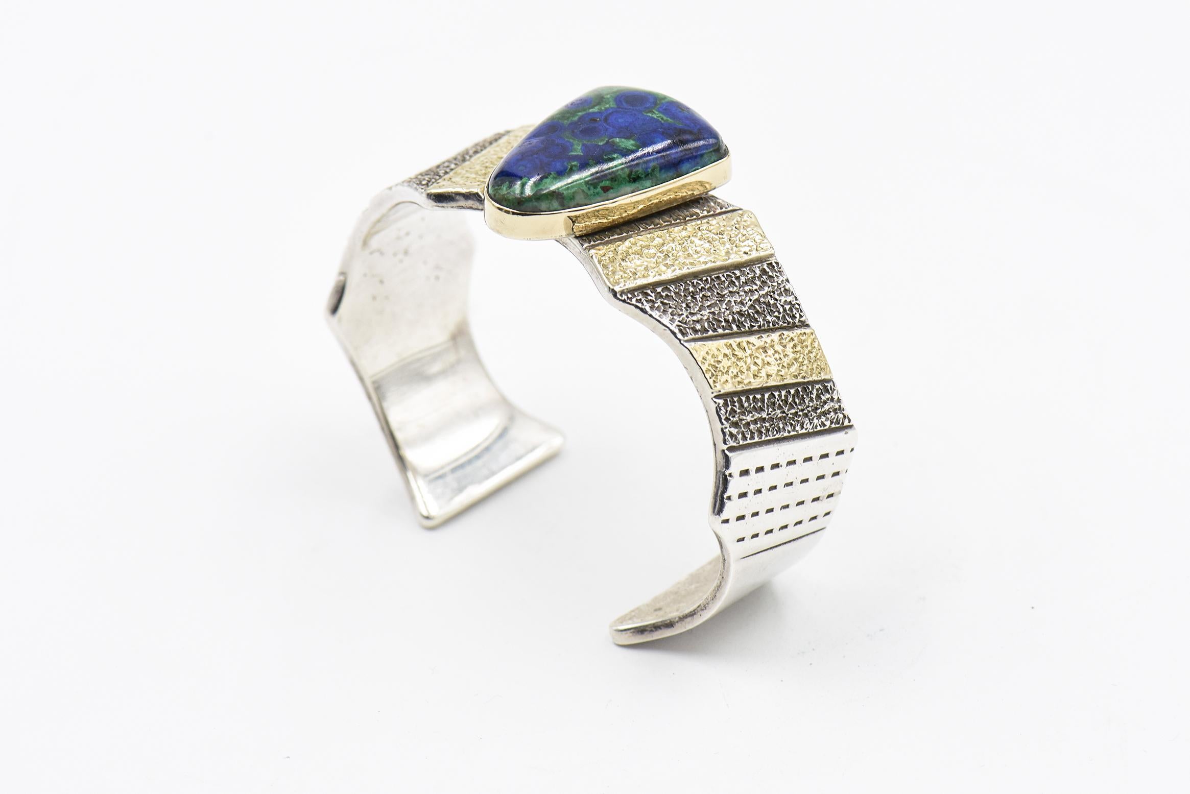 Stunning bracelet designed by Marc Antia featuring a centrally set triangular azurite malachite set in a textured 14k gold and sterling silver cuff bracelet with hand stamped designs in the metal. 

6.5