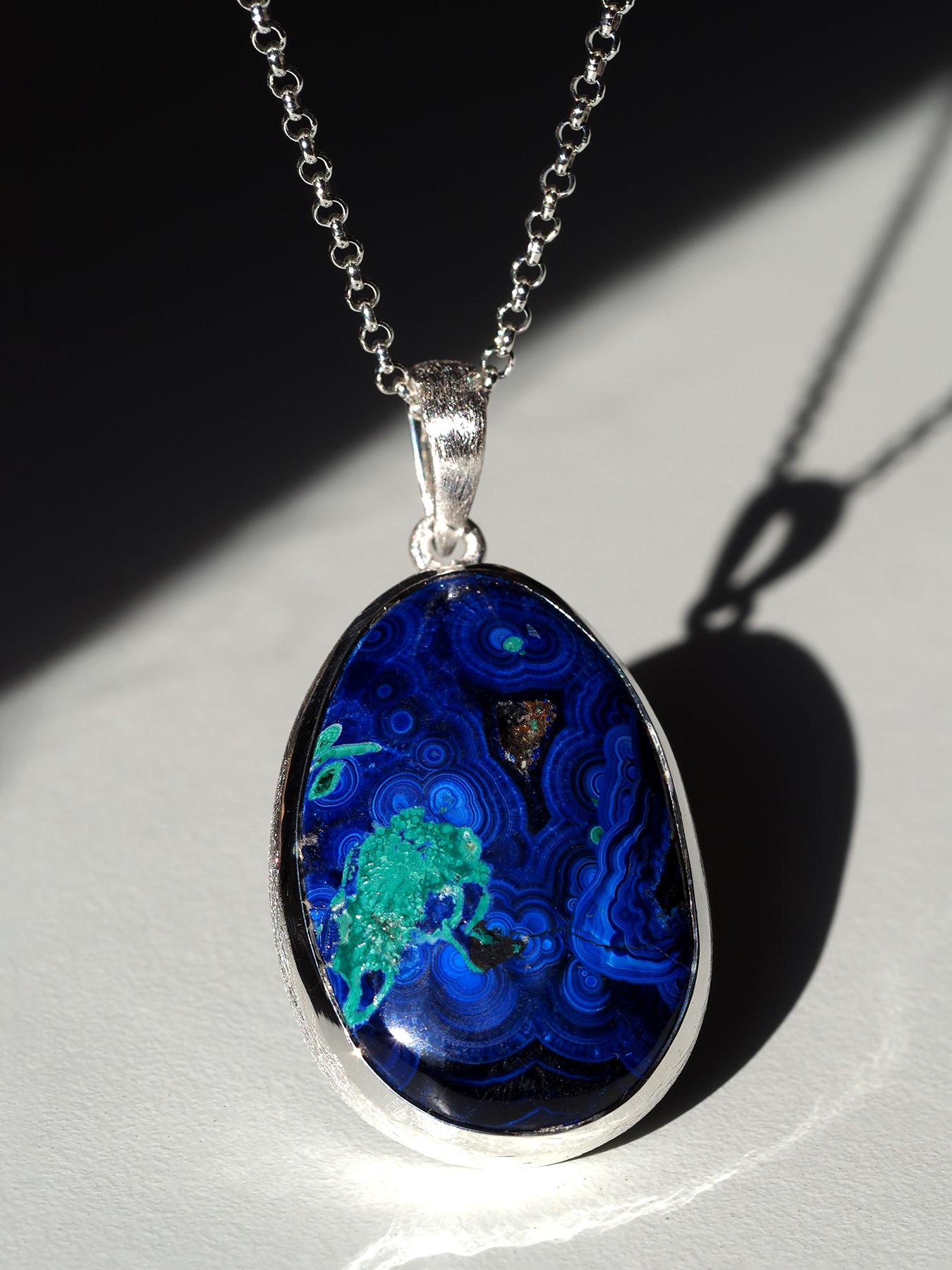 Ciondolo in argento sterling con azzurrite e malachite
Un'audace fusione di terra e arte, questo ciondolo unico nel suo genere presenta un cabochon naturale di azzurrite-malachite con vivaci motivi blu e verdi che evocano paesaggi aerei ed